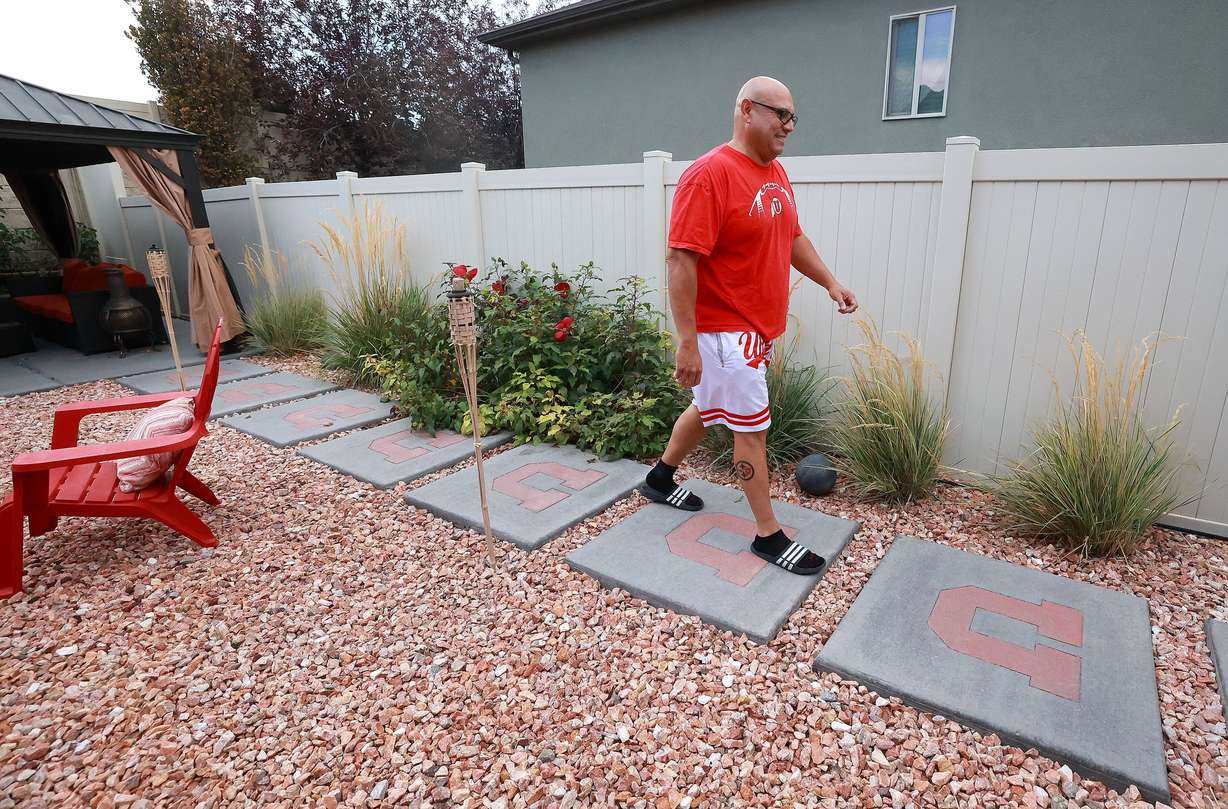 University of Utah football superfan Albert Gamboa walks along U stepping stones as he shows some of the many University of Utah-themed decorations around his house in Riverton on Aug. 24.