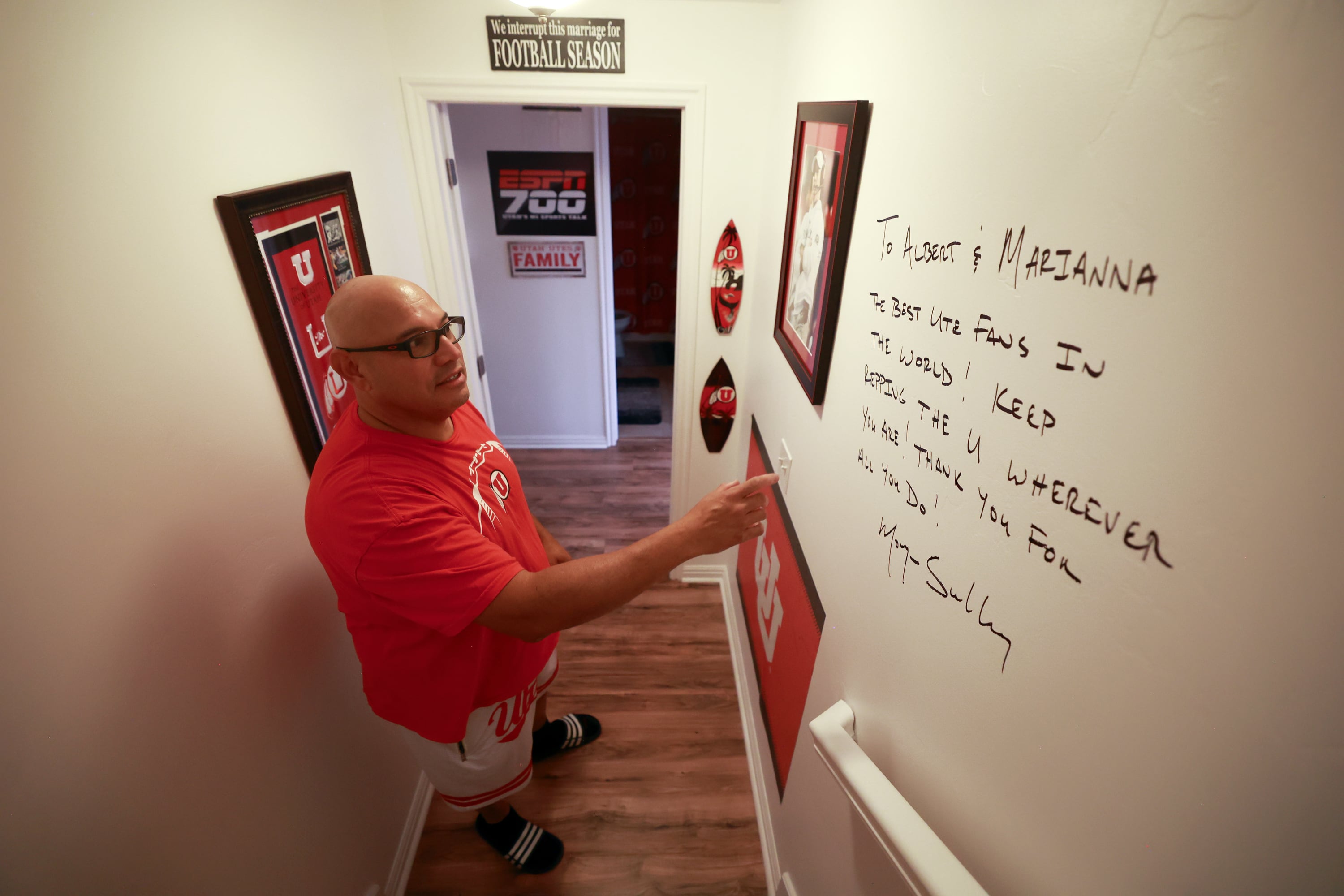 University of Utah football superfan Albert Gamboa shows a note from Utes head football coach Morgan Scalley written on the wall of his University of Utah-themed basement in Riverton on Aug. 24.