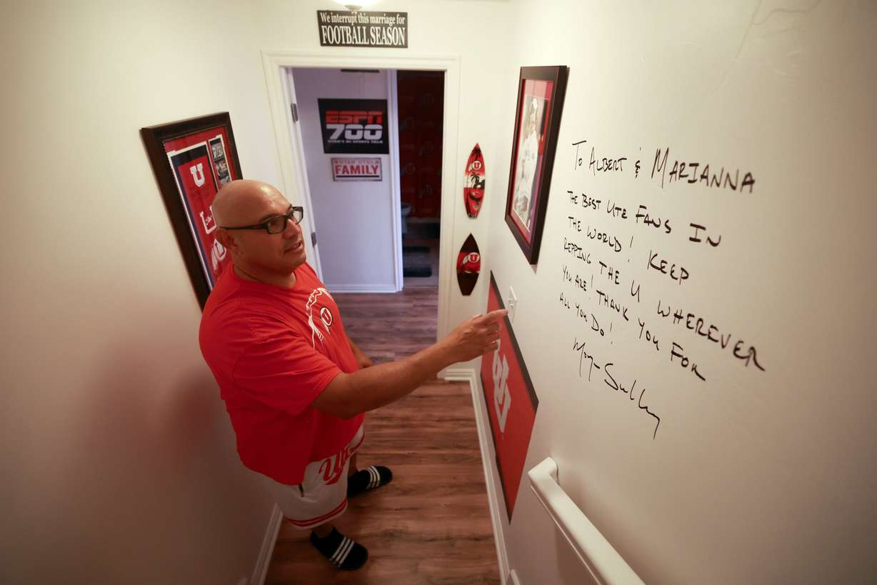 University of Utah football superfan Albert Gamboa shows a note from Utes head football coach Morgan Scalley written on the wall of his University of Utah-themed basement in Riverton on Aug. 24.
