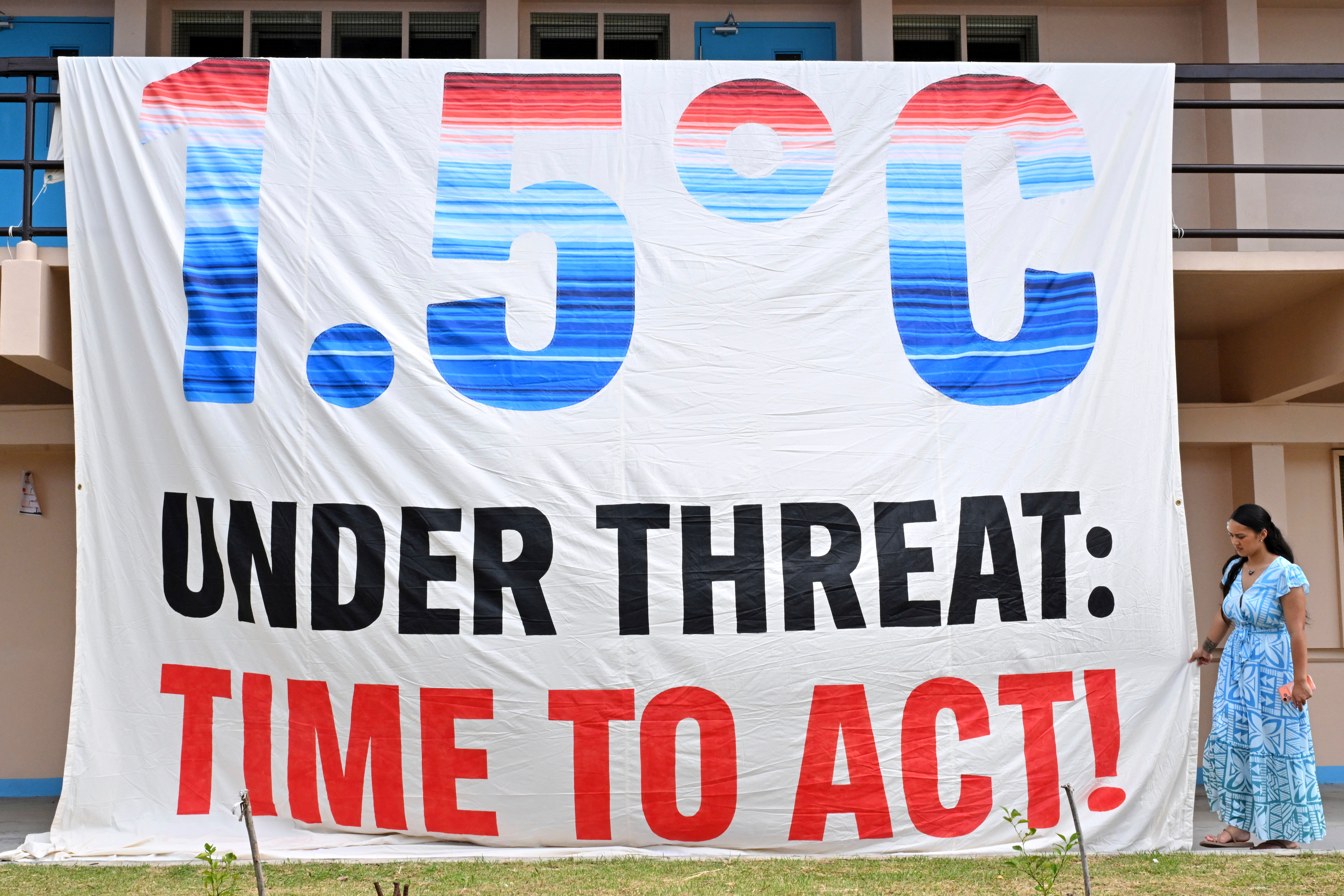 A climate change banner is unfurled by Greenpeace during the Pacific Islands Forum Leaders Meeting in Koror, Palau, Sept. 2. Oatly, the world's largest producer of oat milk, recently joined a climate change awareness campaign.