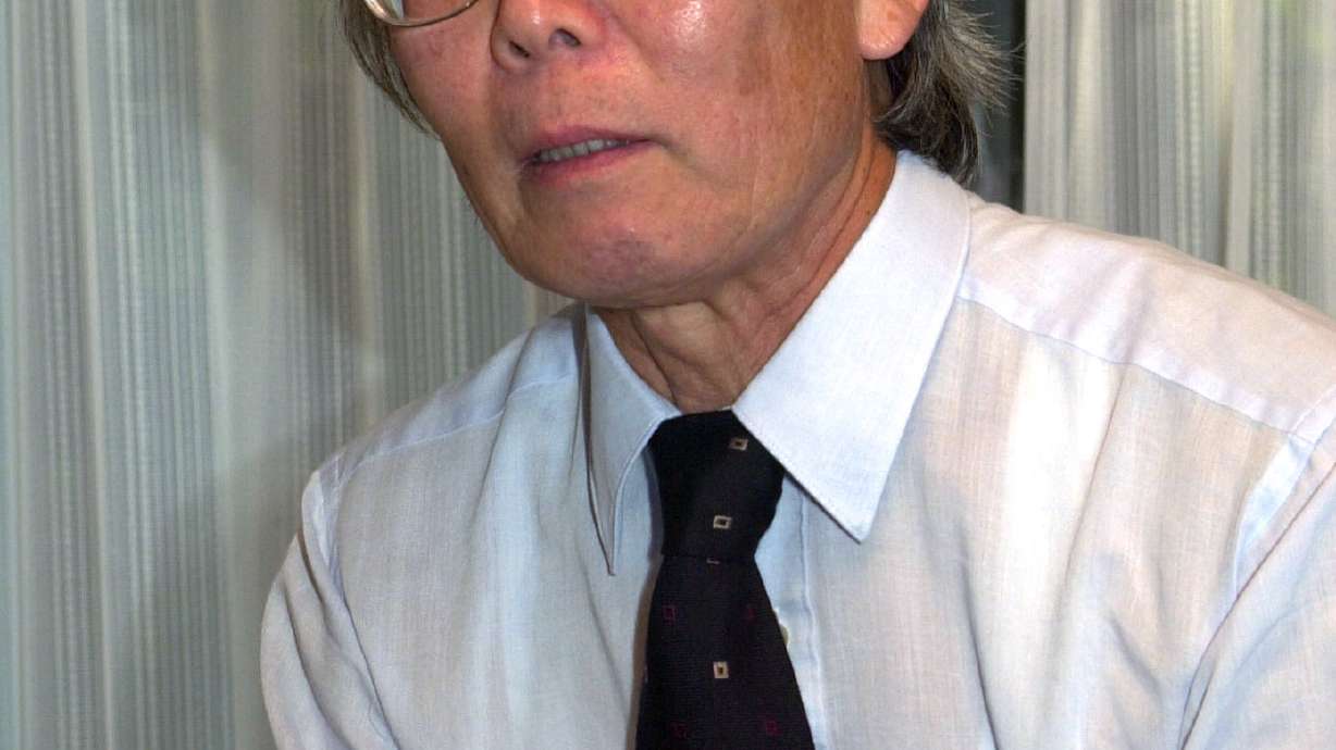 FILE - Japanese Nobel Prize winner, chemist Hideki Shirakawa, speaks with Swedish Embassy Minister Karl Leifland at his home in Yokohama, south of Tokyo, on Oct. 11, 2000.