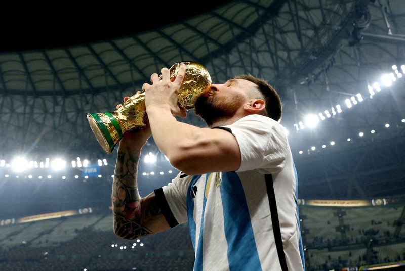 FILE PHOTO: Soccer Football - FIFA World Cup Qatar 2022 - Final - Argentina v France - Lusail Stadium, Lusail, Qatar - December 18, 2022   Argentina's Lionel Messi kisses the trophy as he celebrates winning the World Cup