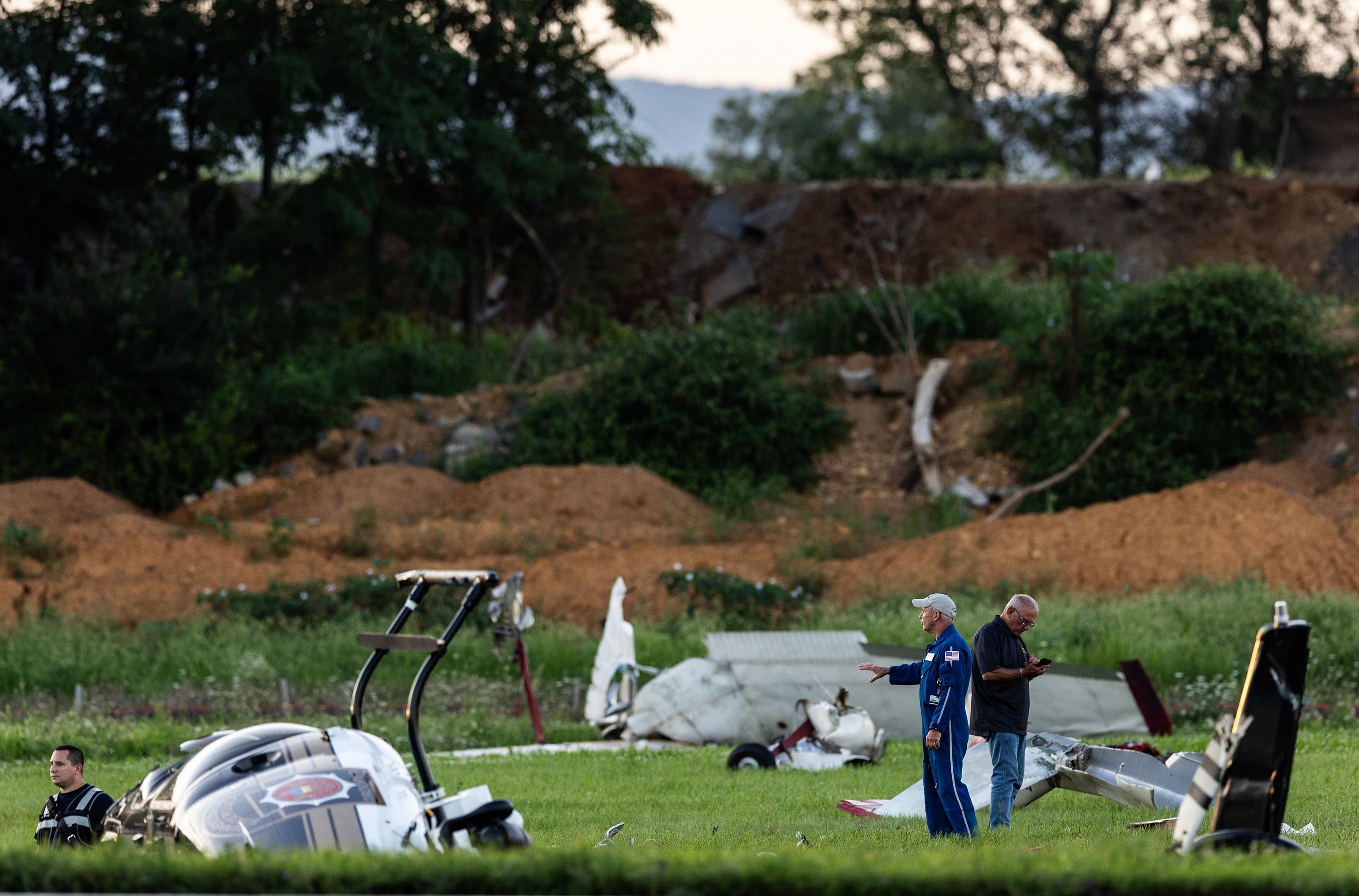 Authorities investigate a crash between a Pennsylvania State Police helicopter and a small plane at the Carlisle airport in Carlisle, Pennsylvania on August 19.