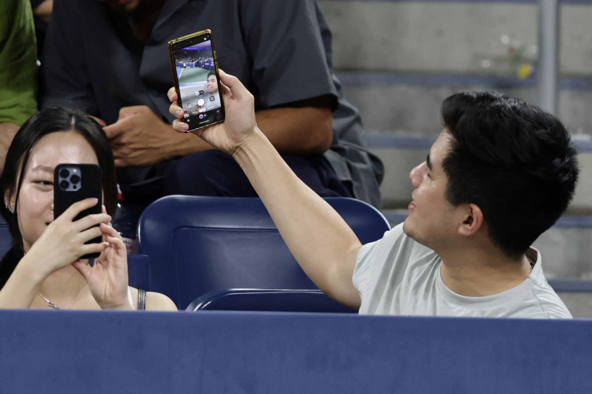 A fan takes a selfie as Elena Rybakina, of Kazakhstan, serves to Jessica Bouzas Maneiro, of Spain, during the second round of the U.S. Open tennis championships, Thursday, Sept. 3, 2026, in New York. 