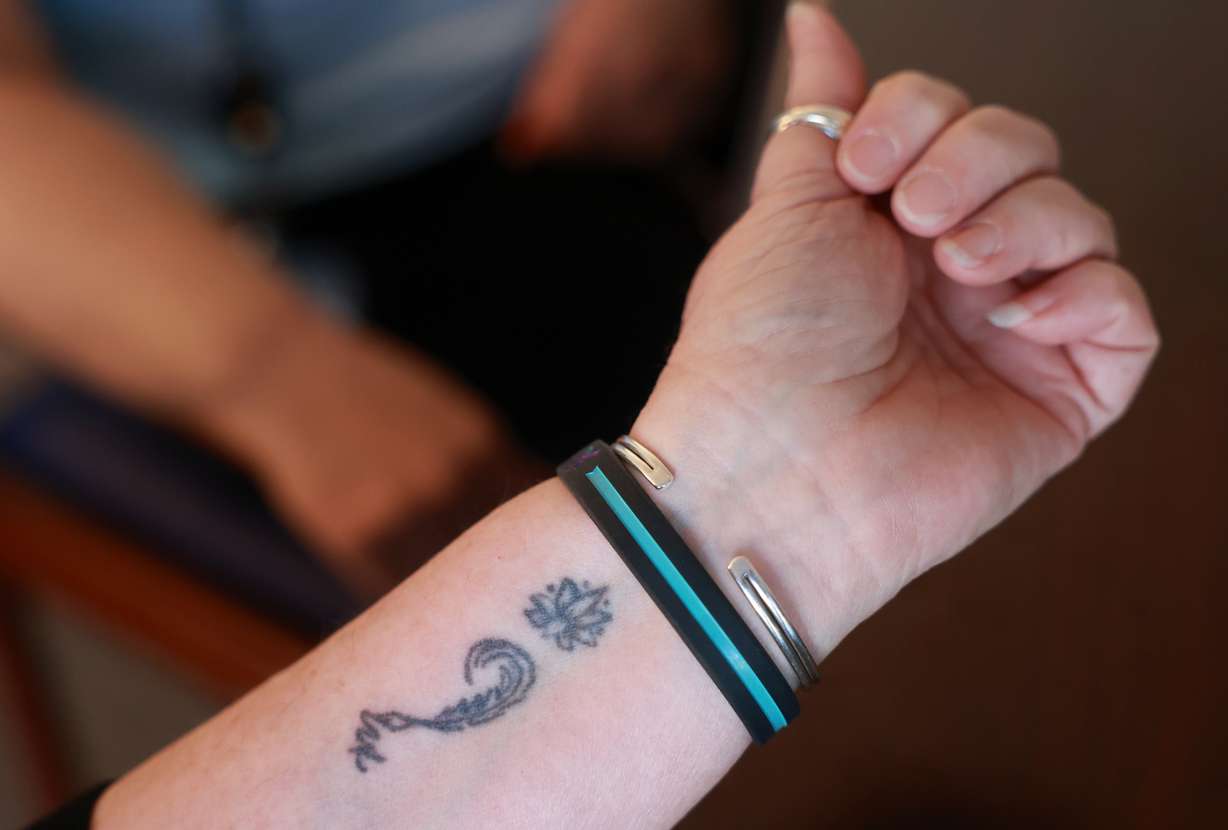 Salt Lake County tax lien coordinator Ray Lancaster, who lost her son to suicide, shows her semicolon tattoo, a symbol of suicide prevention and mental health awareness, in Salt Lake City on Thursday.