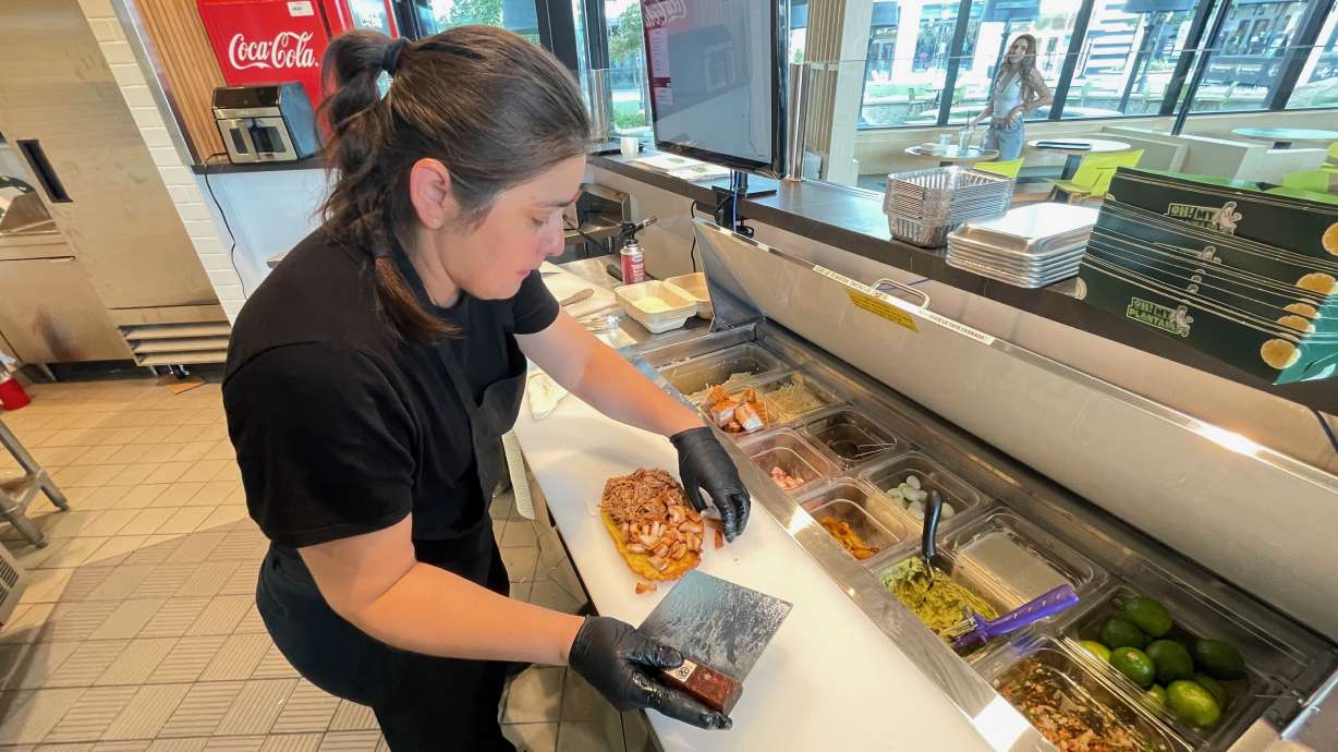 Colombian restaurant operator Steven Rodriguez puts the focus on plantains on the menus of two locales he operates. The photo shows Everlyn Mogollon preparing a patacón at the restaurant's Riverton location on Aug. 26.