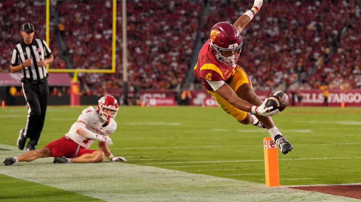 Southern California wide receiver Trent Mosley, right, scores a touchdown as Fresno State defensive back Ethan Tierney watches during the first half of an NCAA college football game, Friday, Sept. 4, 2026, in Los Angeles.