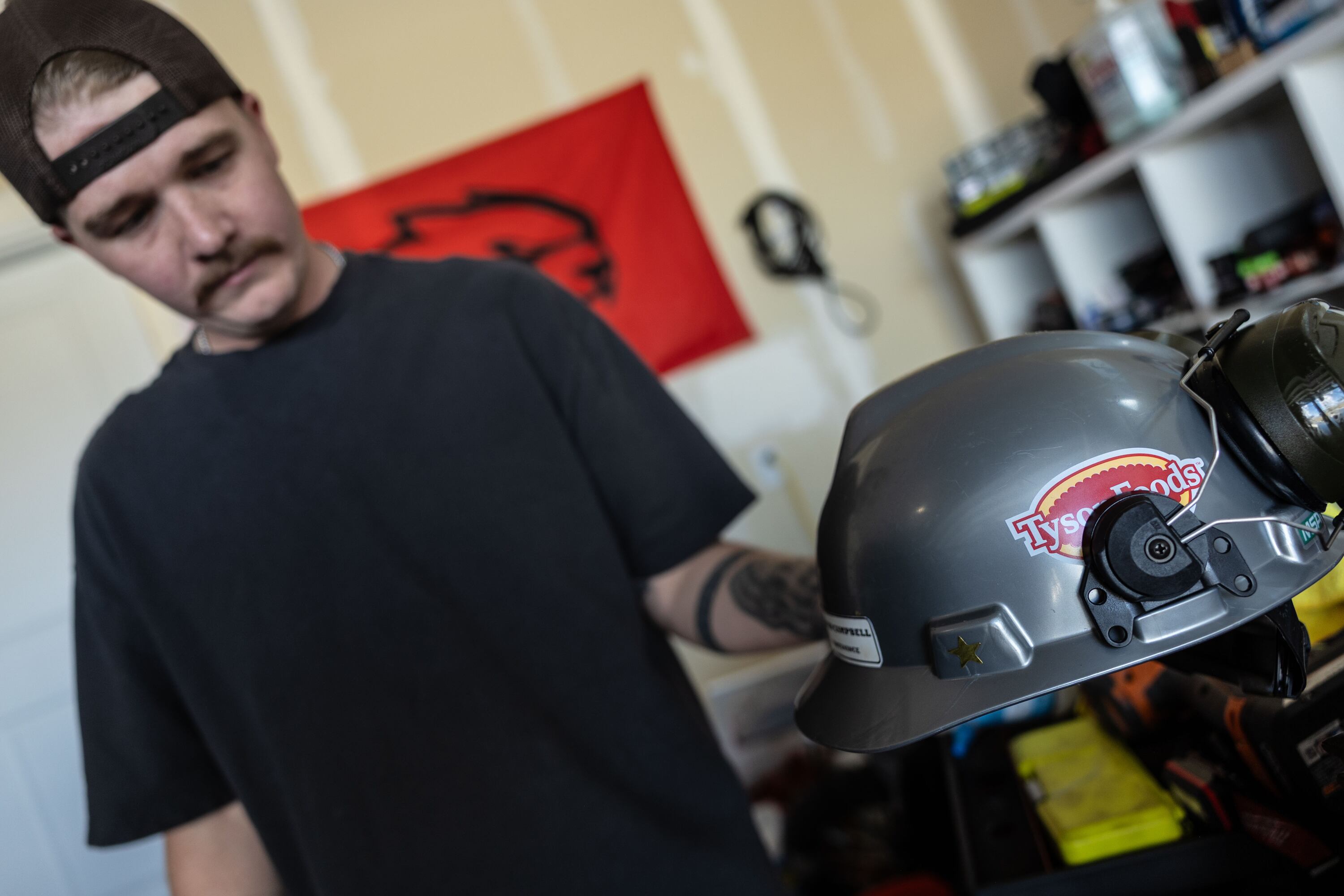Austin Campbell holds up his Tyson Foods hard hat in his home in Eagle Mountain on Tuesday. Campbell is one of many Utahns who have been bitten by a large wave of layoffs.