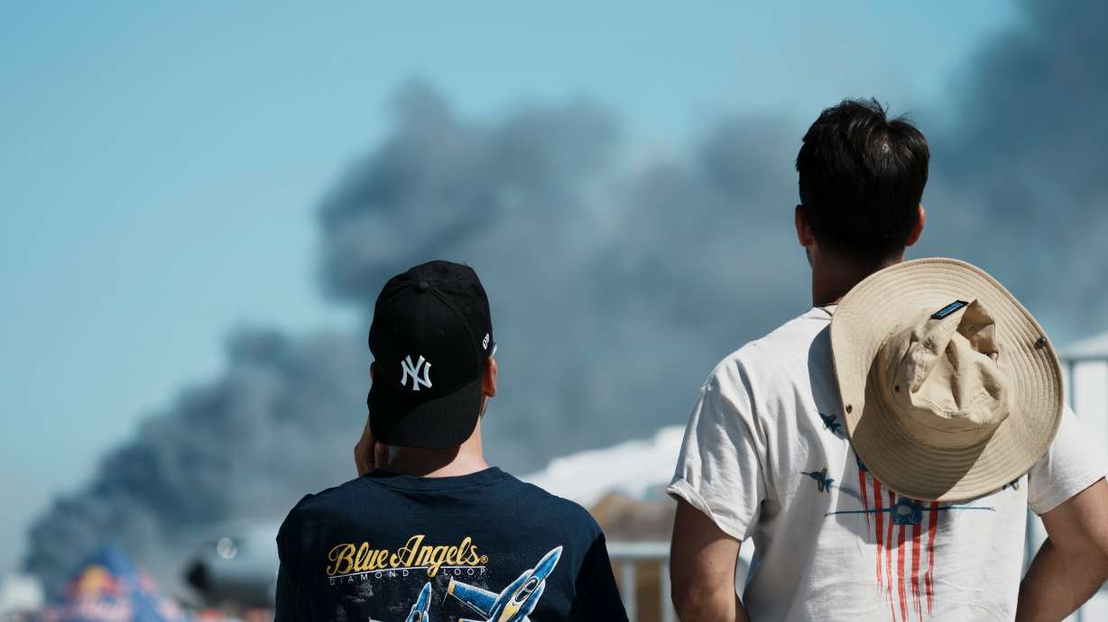 Spectators watch as smoke rises after a Hellenic Air Force F-4 Phantom fighter jet crashed, during the Athens Flying Week airshow at Tanagra Air Force Base, north of Athens, Greece, Saturday. Both pilots of the jet were killed.