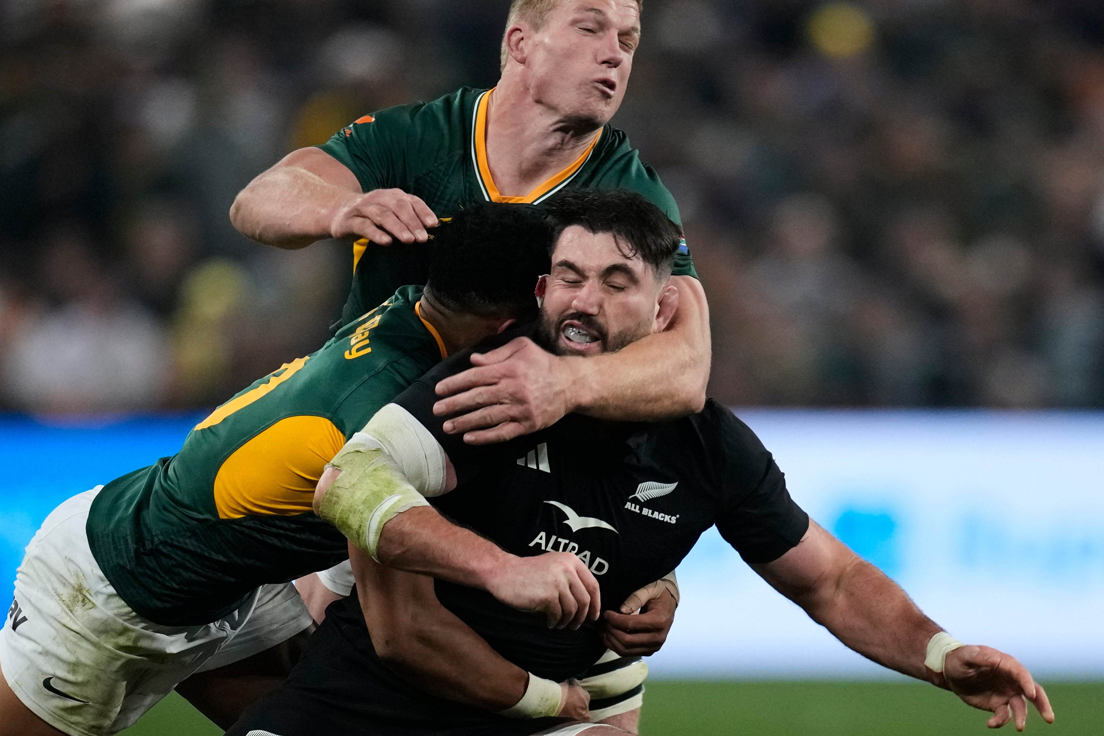 New Zealand's Luke Jacobson, right, is tackled by South Africa's Sacha Feinberg-Mngomezulu, left, and his teammate Pieter-Steph du Toit, during a third international test rugby match between South Africa and New Zealand, in Johannesburg, South Africa, Saturday, Sept. 5, 2026. 