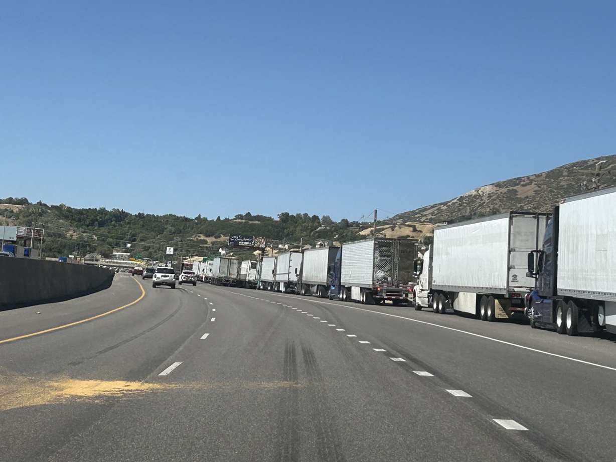 A long line of trucks waits on the side of the road before the turnoff for I-84 off of U.S. 89 near South Weber while crews fight the Broad Fire on Saturday.