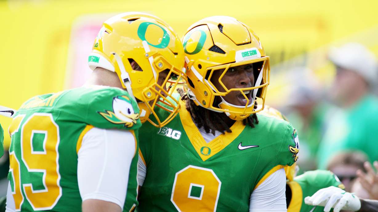 Oregon offensive lineman Fox Crader (59) congratulates tight end Jamari Johnson (9) on a touchdown during the first half of an NCAA college football game against Boise State, Saturday, Sept. 5, 2026, in Eugene, Ore.