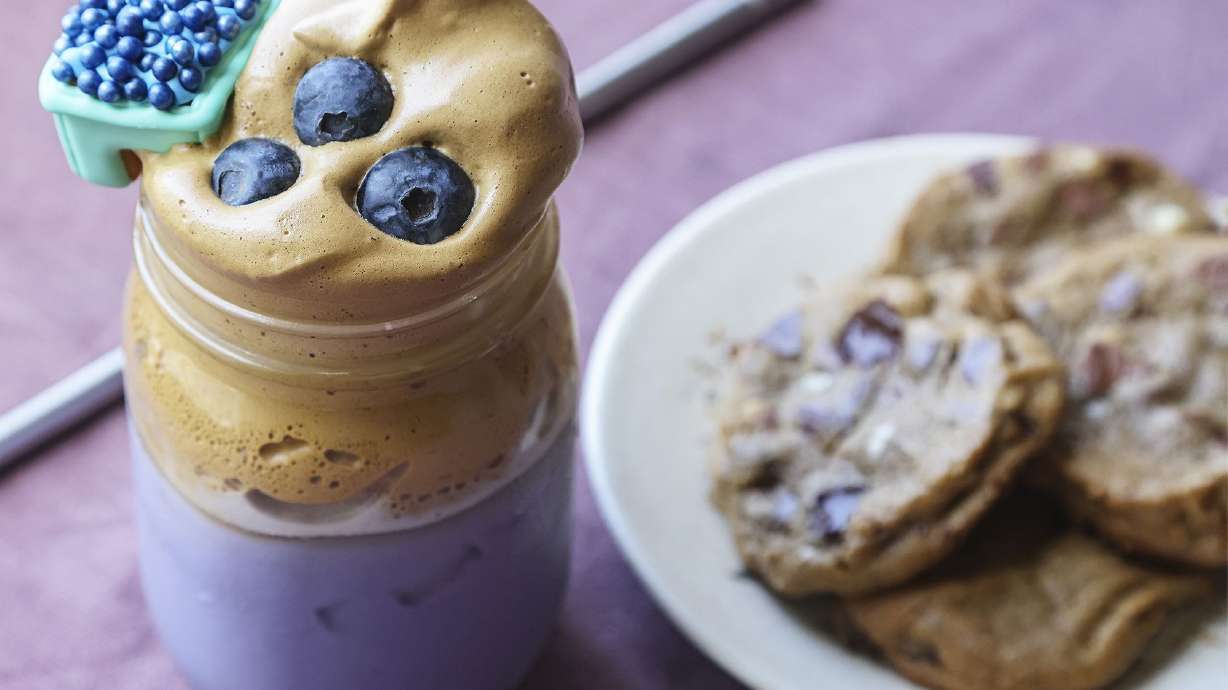 Blueberry Dalgona Coffee recipe, prepared by Lauren J. Mapp at her home in San Diego, CA, in April 2021. Topped with blueberries and adorned with a Mug Buddy Cookie (left) and Chocolate Chip Cookies (right).