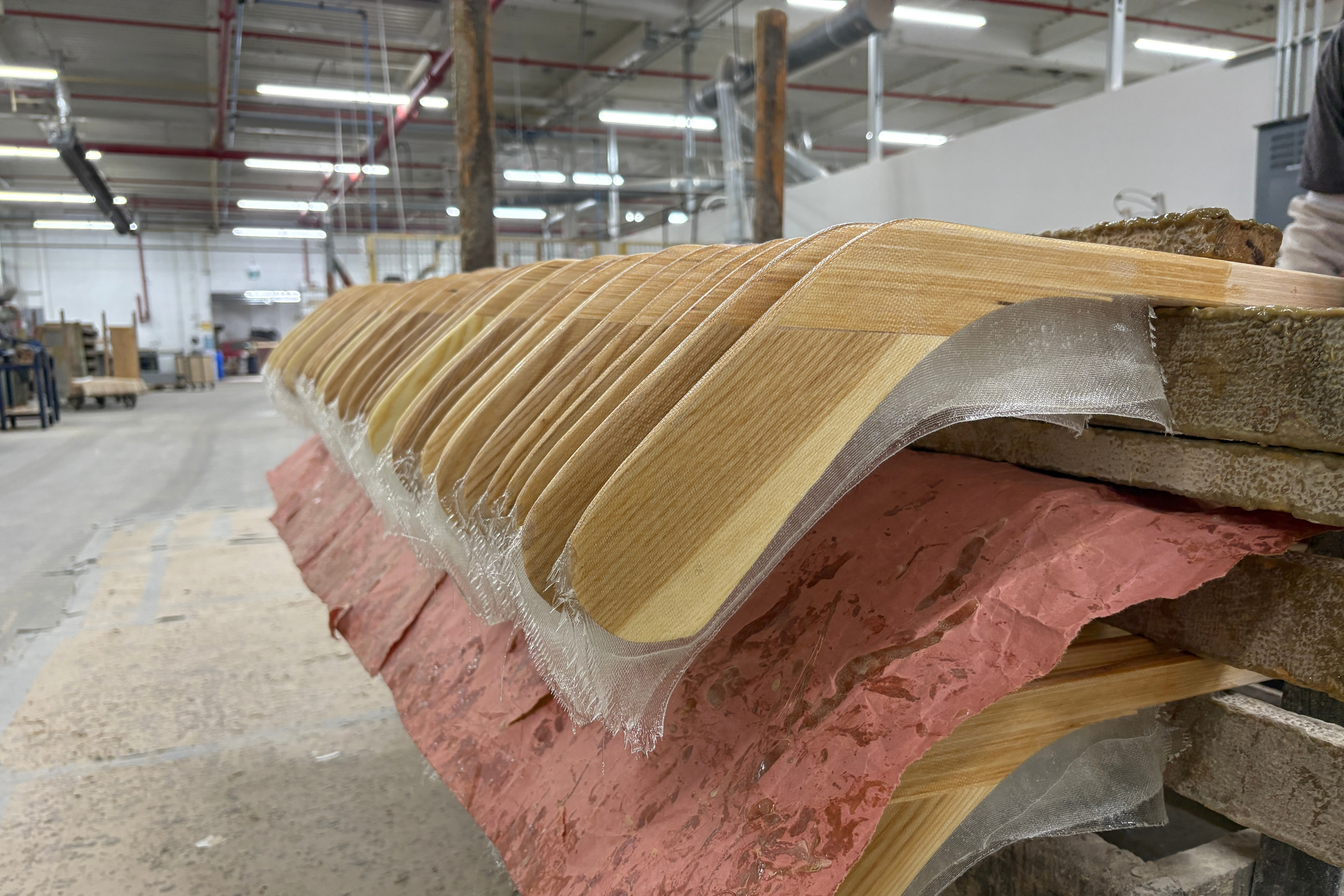 FILE - Wooden hockey sticks are stacked as they move along the assembly line at the Roustan Hockey factory, which is the last major manufacturer of hockey sticks in Canada on Aug. 27, 2025 in Brantford, Ontario. 