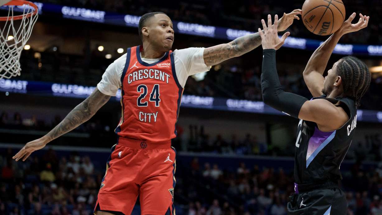 FILE - New Orleans Pelicans guard Jordan Hawkins (24) blocks the shot of Utah Jazz guard Kennedy Chandler (0) during the first half of an NBA basketball game in New Orleans, April 7, 2026.