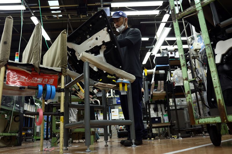 FILE PHOTO: An employee works on the assembly line at Nanjo Auto Interior, a manufacturer of inside door panels and other parts for Mazda Motor, in Akitakata, Hiroshima Prefecture, Japan July 14, 2025.