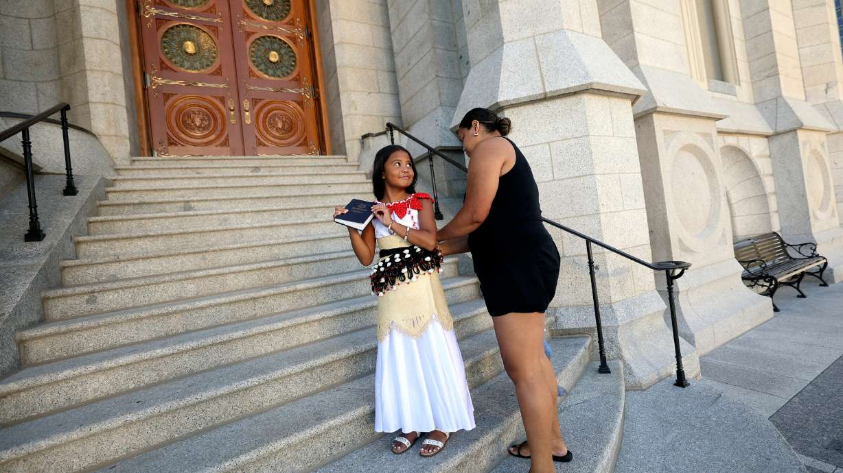 Ofakipouono Fusitua looks at her great-aunt Elenoa Lutui as Lutui preps Fusitua for baptism photos outside of the Salt Lake Temple on Temple Square in Salt Lake City on Tuesday. Areas that were previously barricaded off are now open.