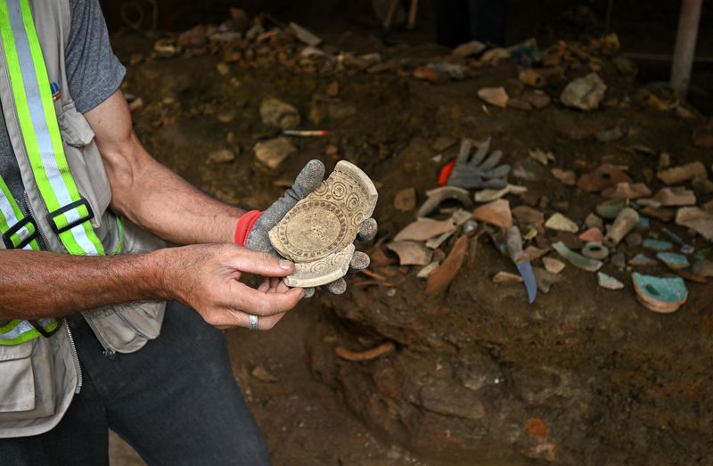 Archaeologist Merab Dzneladze demonstrates an artifact at an excavation site in central Tbilisi, Georgia, September 1, 2026. Recent city centre renovation works exposed a cache of 10th-century pottery, which will be moved to the National Museum for 3D scanning and review.