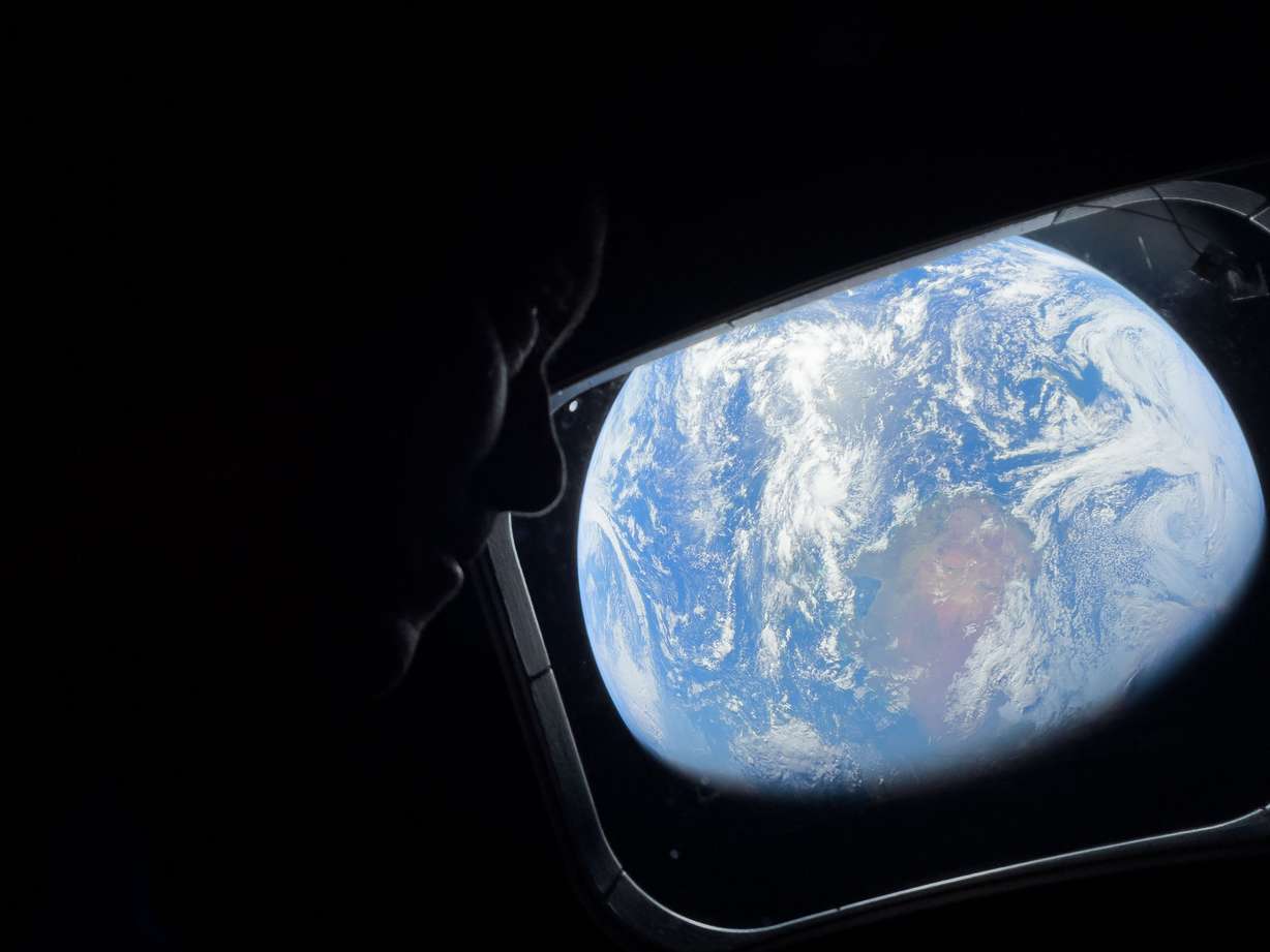 NASA astronaut and Artemis II Commander Reid Wiseman peers out of one of the Orion spacecraft's main cabin windows, looking back at Earth, as the crew travels towards the Moon on April 4, 2026. NASA's Artemis II mission will take Wiseman, Glover, Koch, and Hansen on a 10-day journey around the Moon and back aboard their Orion spacecraft.