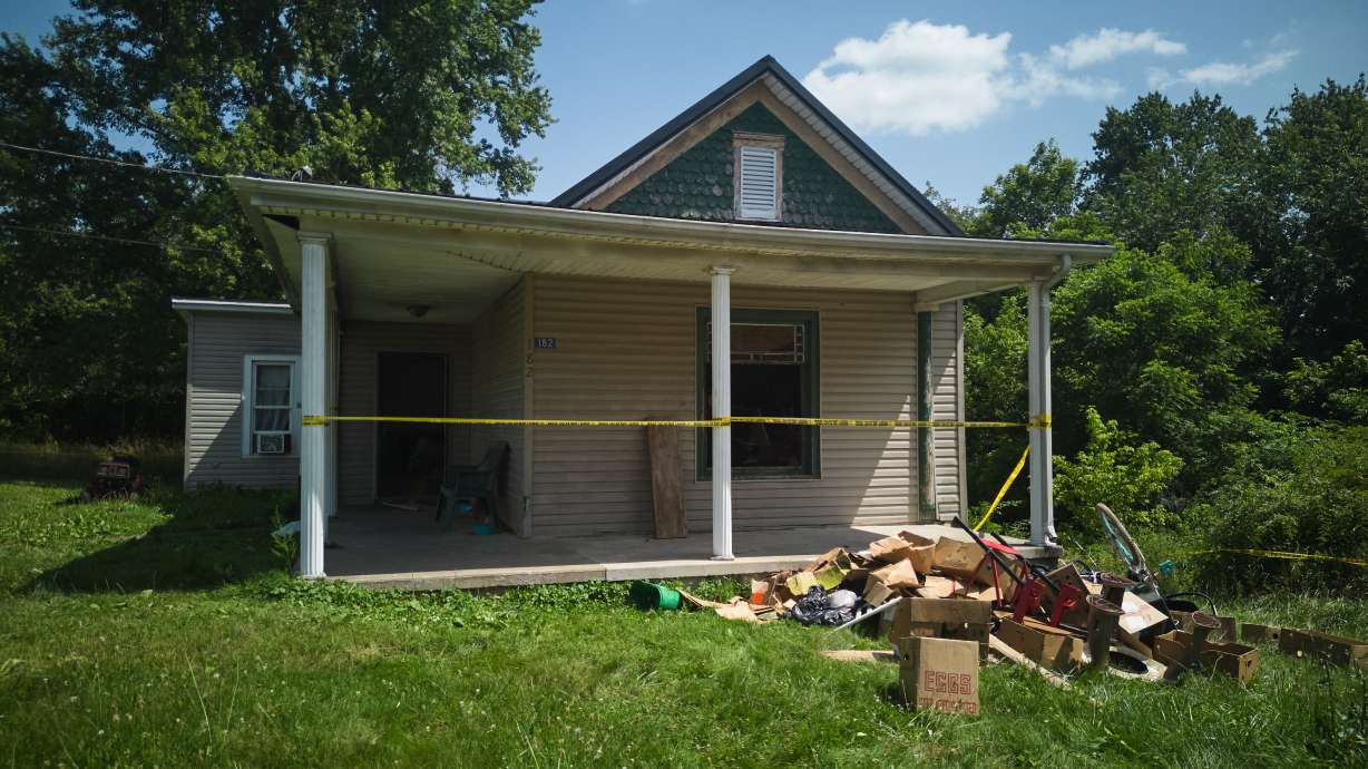 Police tape surrounds a home where authorities say they removed 16 children and arrested four adults in Hamden, Ohio, July 1. A man whose 16 grandchildren were discovered living in squalid conditions at a rural southern Ohio home was found mentally incompetent to stand trial Wednesday.