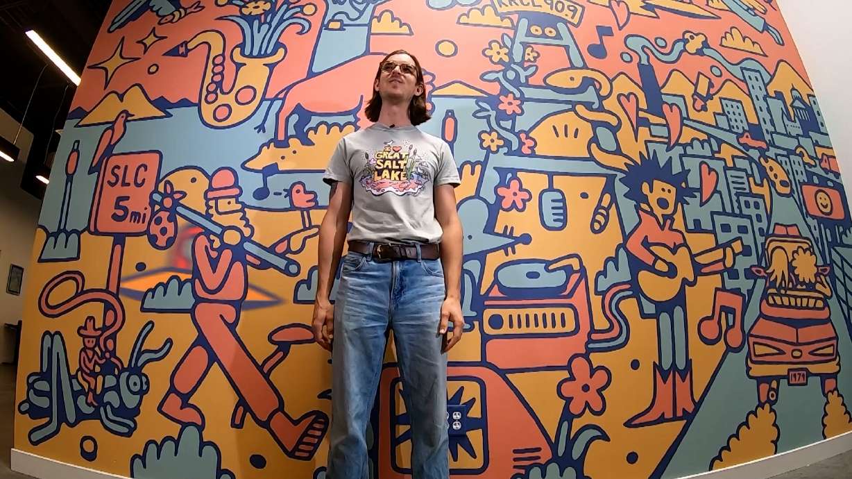 Trevor Dahl stands in front of a mural at KRCL.