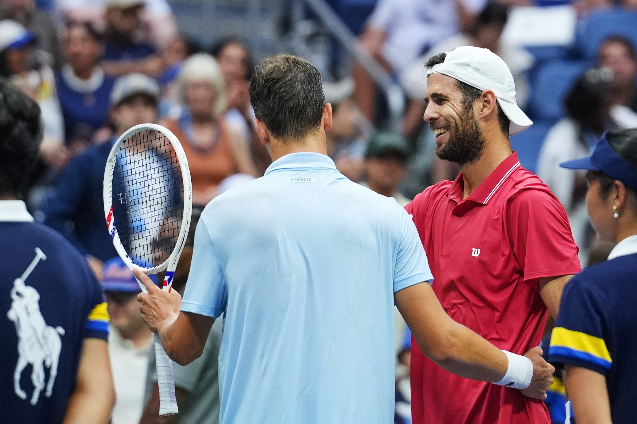Alexander Blockx, of Belgium, left, meets Karen Khachanov, of Russia, at the net after Blockx was forced to retire due to an apparent injury during the quarterfinal round of the U.S. Open tennis championships, Wednesday, Sept. 9, 2026, in New York. 