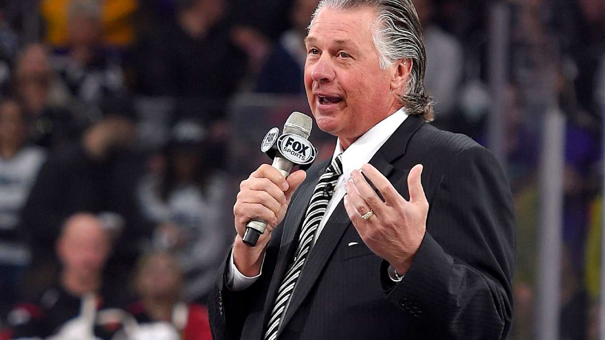 FILE - Former Los Angeles Kings coach Barry Melrose speaks to fans as he is honored prior to an NHL hockey game between the Kings and the Calgary Flames, on Feb. 12, 2015, in Los Angeles.