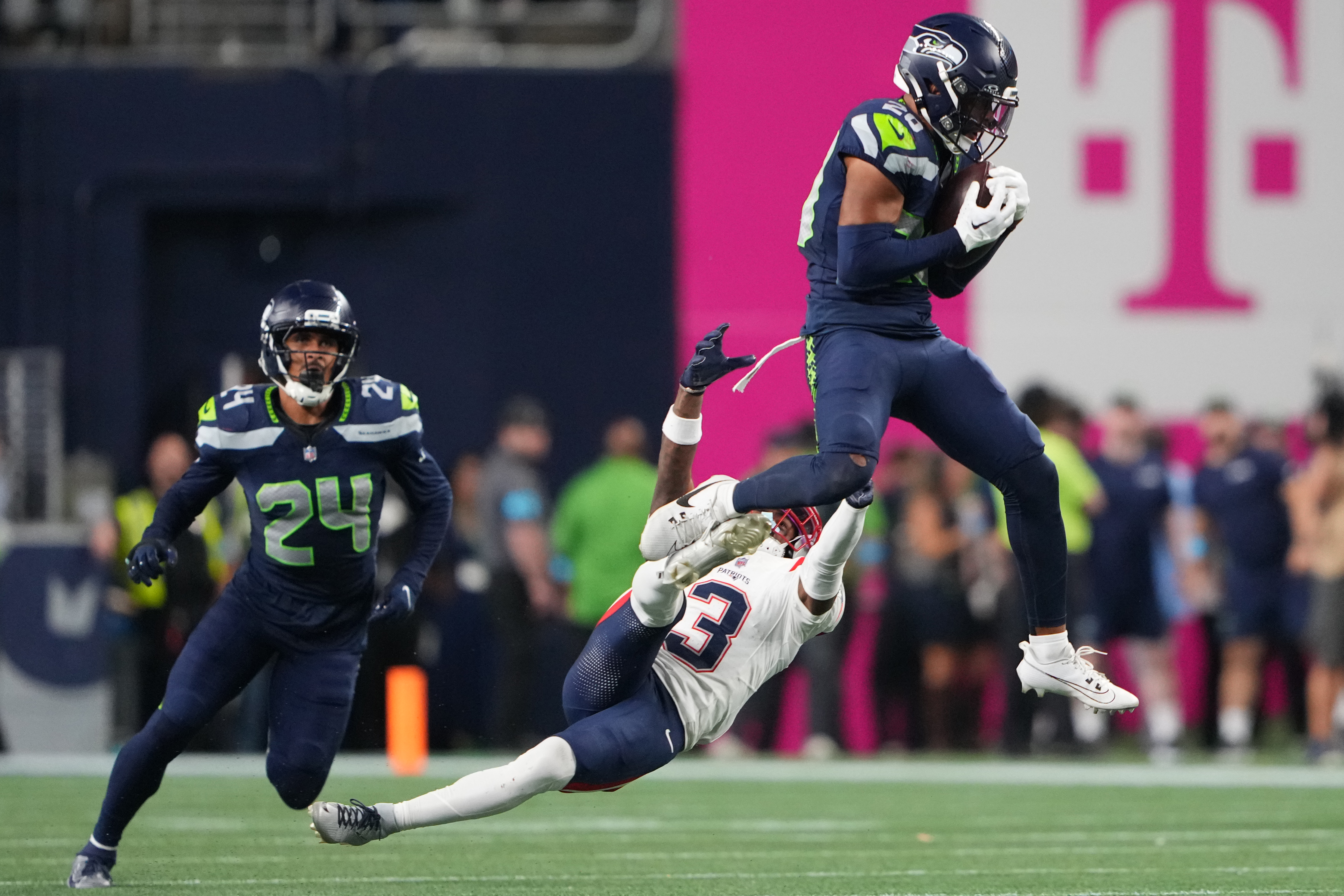 Seattle Seahawks safety Julian Love (20) intercepts a pass intended for New England Patriots wide receiver DeMario Douglas (3) as New England Patriots safety Dell Pettus (24) looks on during the second half of an NFL football game, Wednesday, Sept. 9, 2026, in Seattle. 