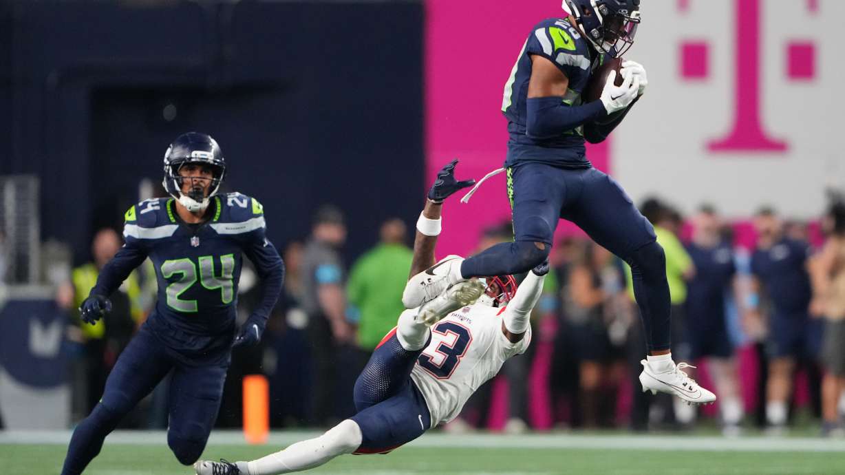 Seattle Seahawks safety Julian Love (20) intercepts a pass intended for New England Patriots wide receiver DeMario Douglas (3) as New England Patriots safety Dell Pettus (24) looks on during the second half of an NFL football game, Wednesday, Sept. 9, 2026, in Seattle.