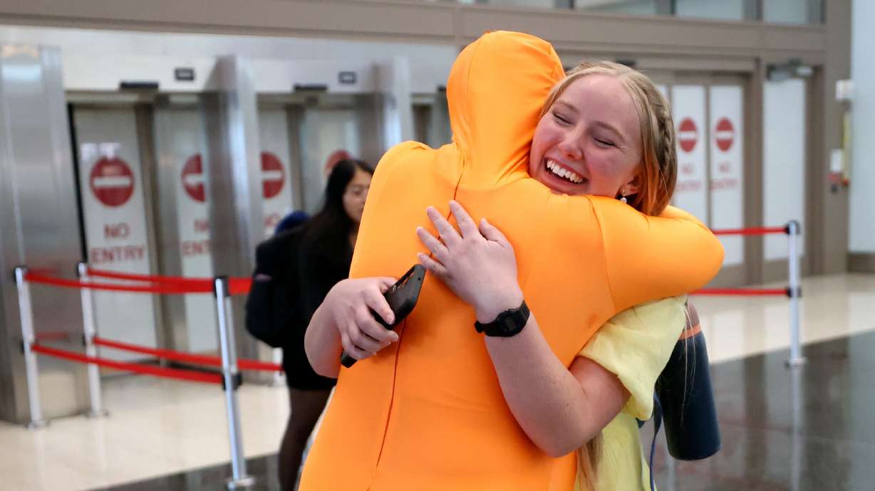 Samantha Timm, dressed as The Lorax, hugs her sister, Hailey Timm, at Salt Lake City International Airport as Hailey returns from a mission for The Church of Jesus Christ of Latter-day Saints on Wednesday. The TSA has a new program that allows for access to gate areas in 13 airports, including Salt Lake City.