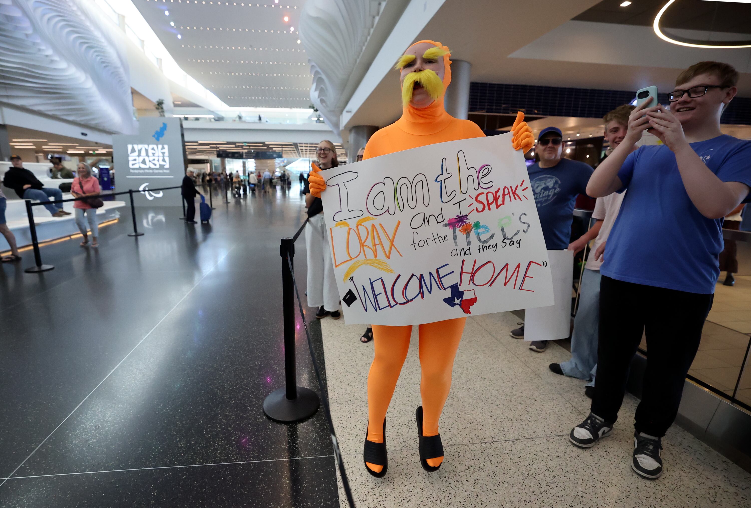 Samantha Timm, dressed as The Lorax, jumps as she sees her sister approaching as she returns from a mission for The Church of Jesus Christ of Latter-day Saints at Salt Lake City International Airport, Wednesday. Some relatives of returning missionaries may not need to wait as long to see them with thanks to a new TSA program.