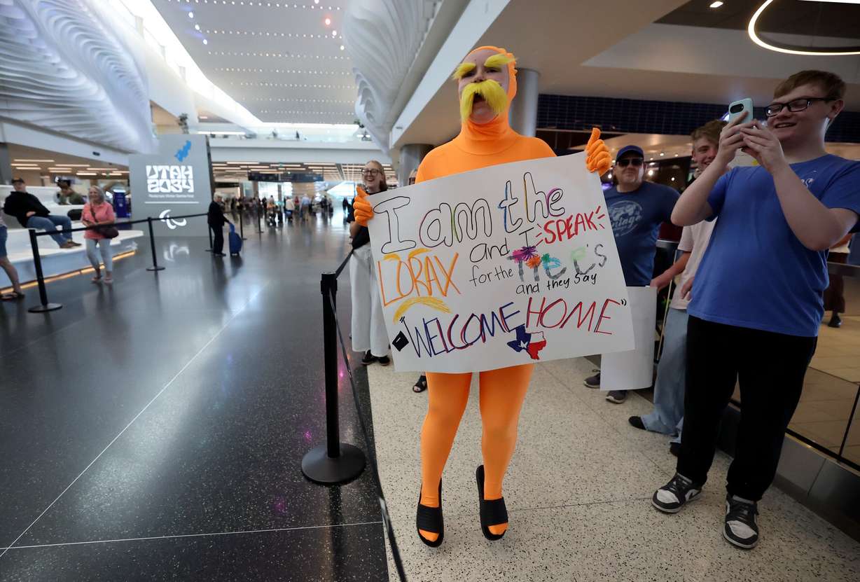 Samantha Timm, dressed as The Lorax, jumps as she sees her sister approaching as she returns from a mission for The Church of Jesus Christ of Latter-day Saints at Salt Lake City International Airport, Wednesday. Some relatives of returning missionaries may not need to wait as long to see them with thanks to a new TSA program.