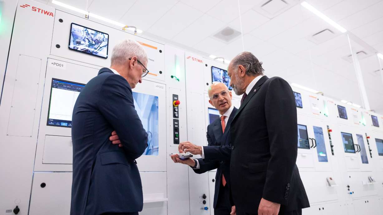 Apple COO Sabih Khan and then-CEO Tim Cook give Secretary of Commerce Howard Lutnick a tour of a learning lab at Apple's Advanced Manufacturing Center in Houston, Aug. 13. Wholesale inflation picked up last month after cooling earlier this summer.