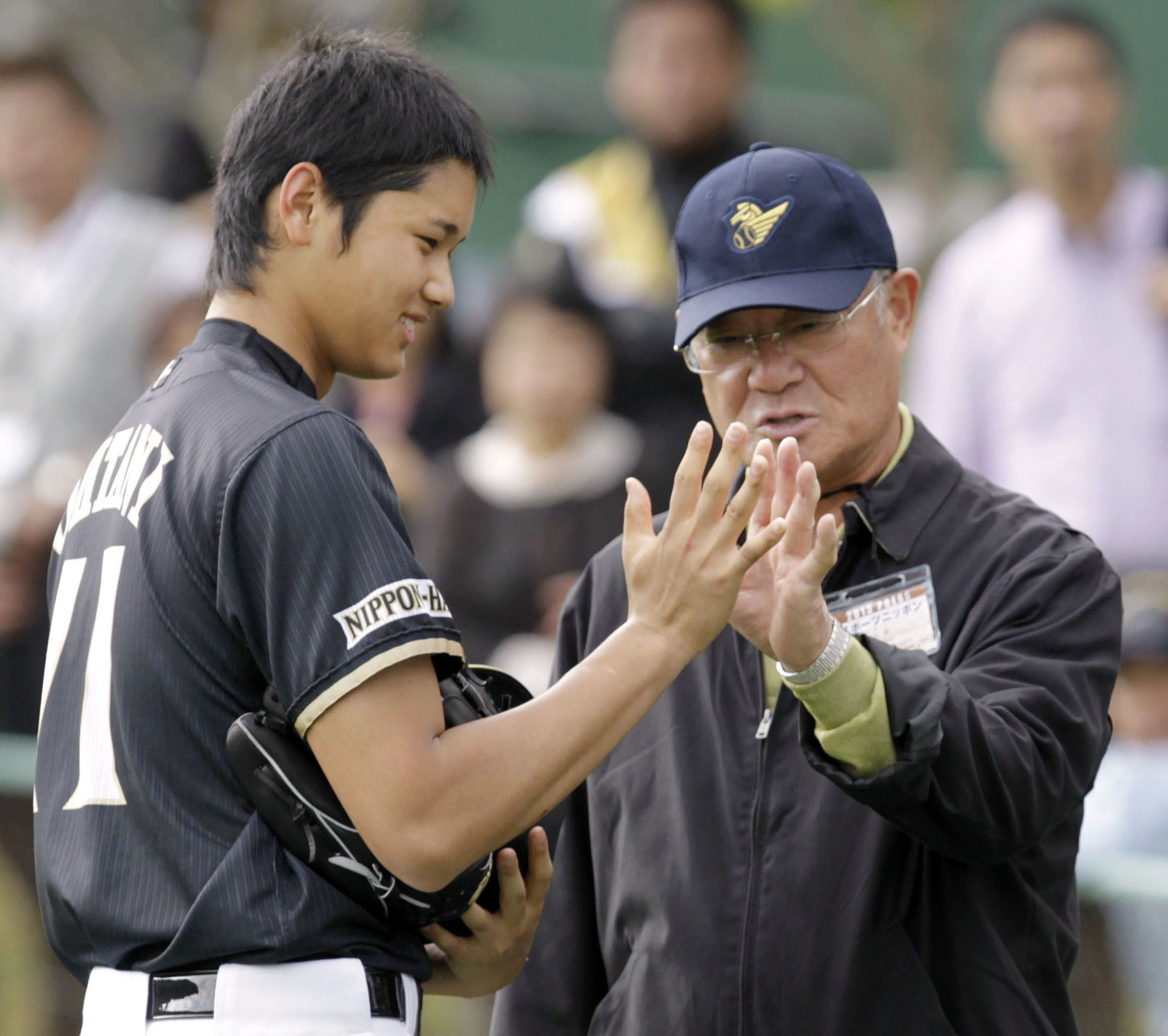 Former professional baseball player Isao Harimoto, right, compares the size of his hand with Hokkaido Nippon-Ham Fighters player Shohei Ohtani, in Kunigami, Okinawa Prefecture, Japan, Feb. 2013. 