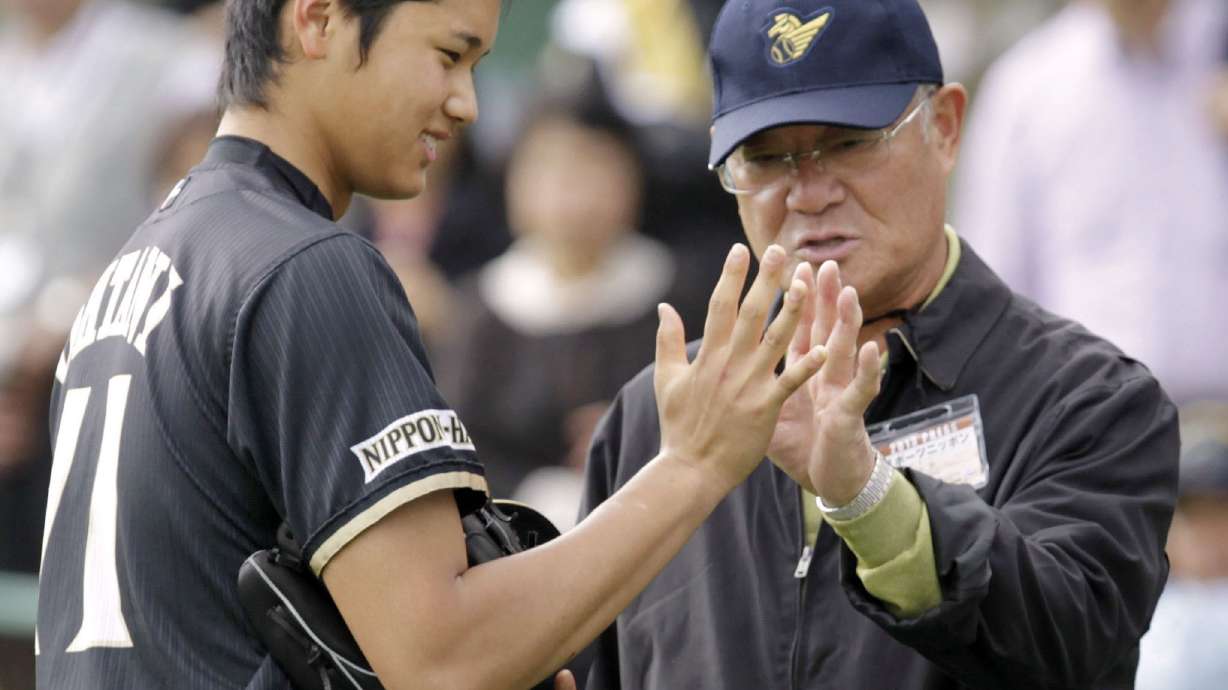 Former professional baseball player Isao Harimoto, right, compares the size of his hand with Hokkaido Nippon-Ham Fighters player Shohei Ohtani, in Kunigami, Okinawa Prefecture, Japan, Feb. 2013.
