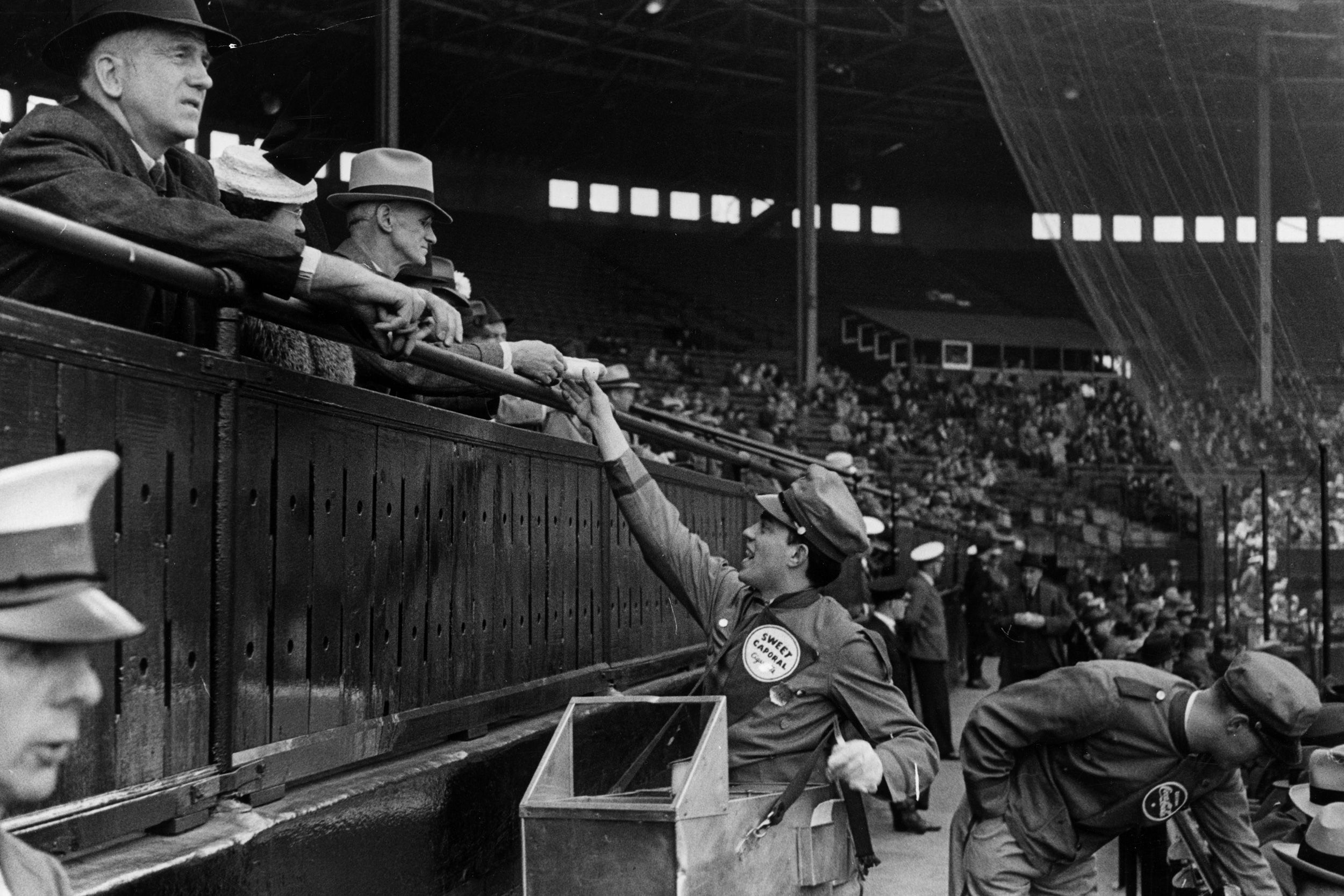 A hot dog seller distributes his goods at a Canadian baseball game in 1939.