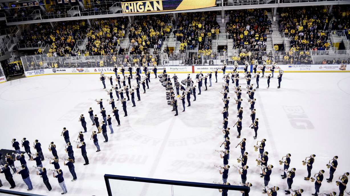 FILE - The Michigan Marching Band performs at the end of the first period during an NCAA college men's hockey game between Michigan State and Michigan, Jan. 9, 2016, in Ann Arbor, Mich.