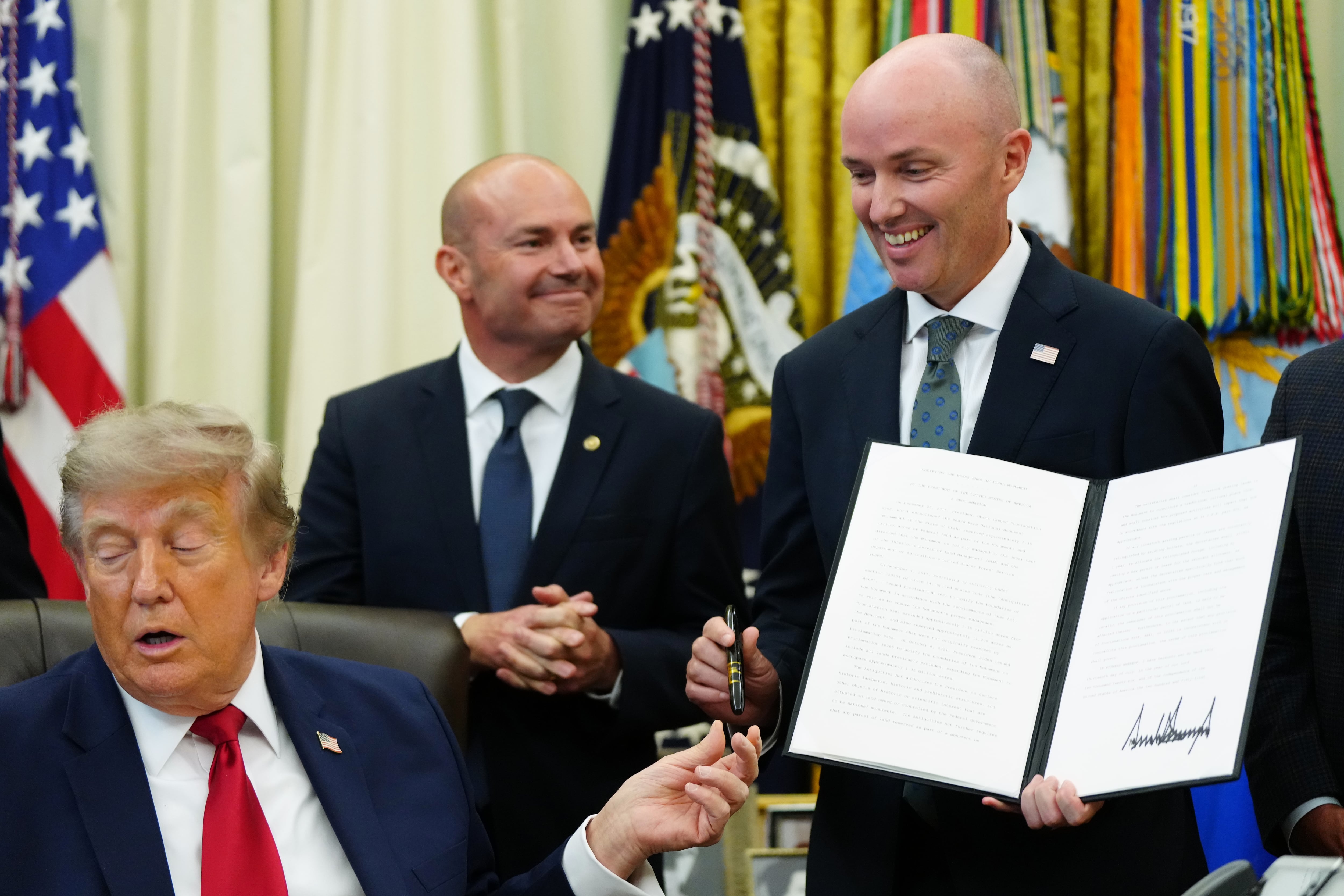 President Donald Trump hands a pen to Utah Gov. Spencer Cox after signing executive orders modifying the Grand Staircase-Escalante National Monument and the Bears Ears National Monument in the Oval Office of the White House, July 13, in Washington.