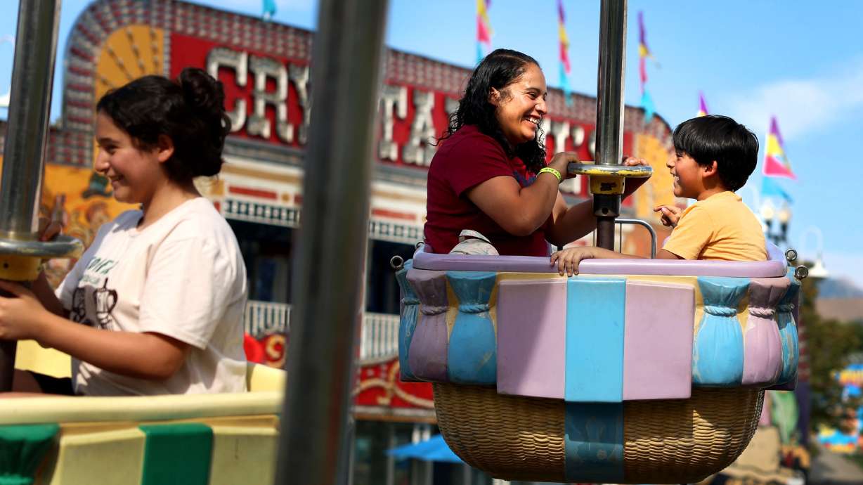Guadalupe Bravo, center, and her children, daughter Katherine Batalla and son Erik Batalla, enjoy a ride at the Utah State Fairpark in Salt Lake City on Sept. 4, 2025.