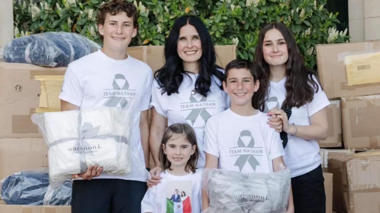 Members of the Peterson family hand out blankets at Huntsman Cancer Institute. The Saranoni Cares program was started by Nathan Peterson, who created the program a few months before he died from cancer.