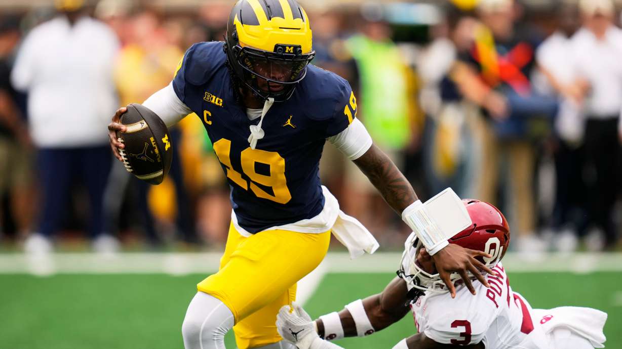 Michigan quarterback Bryce Underwood (19) escapes the tackle of Oklahoma defensive back Reggie Powers III (3) in the first half of an NCAA college football game Saturday, Sept. 12, 2026, in Ann Arbor, Mich.