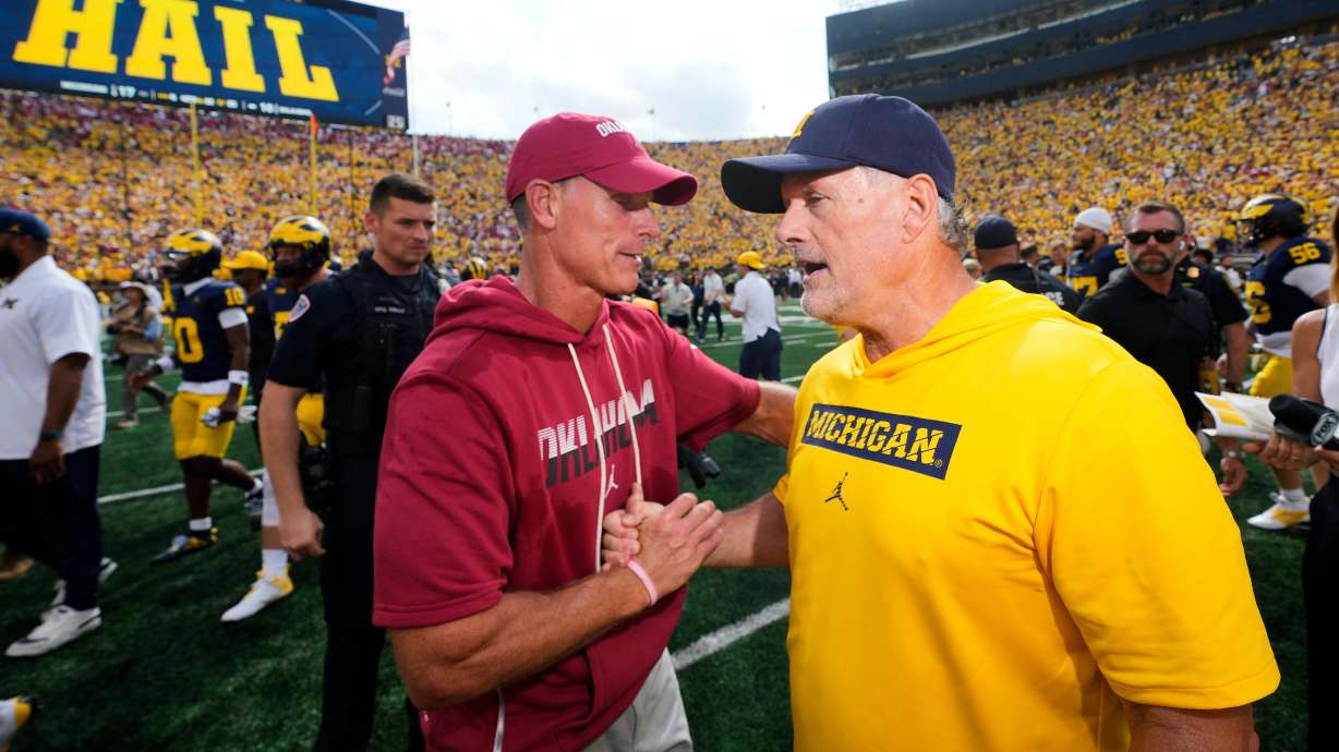 Oklahoma head coach Brent Venables, left, and Michigan head coach Kyle Whittingham, right, shake hands after an NCAA college football game Saturday, Sept. 12, 2026, in Ann Arbor, Mich.