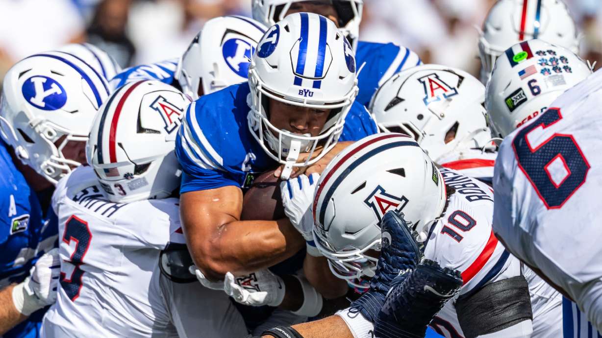 BYU Cougars running back LJ Martin (4) pushes the pile forward as he runs with the ball during a football game against Arizona at LaVell Edwards Stadium in Provo on Saturday, Sept. 12, 2026.