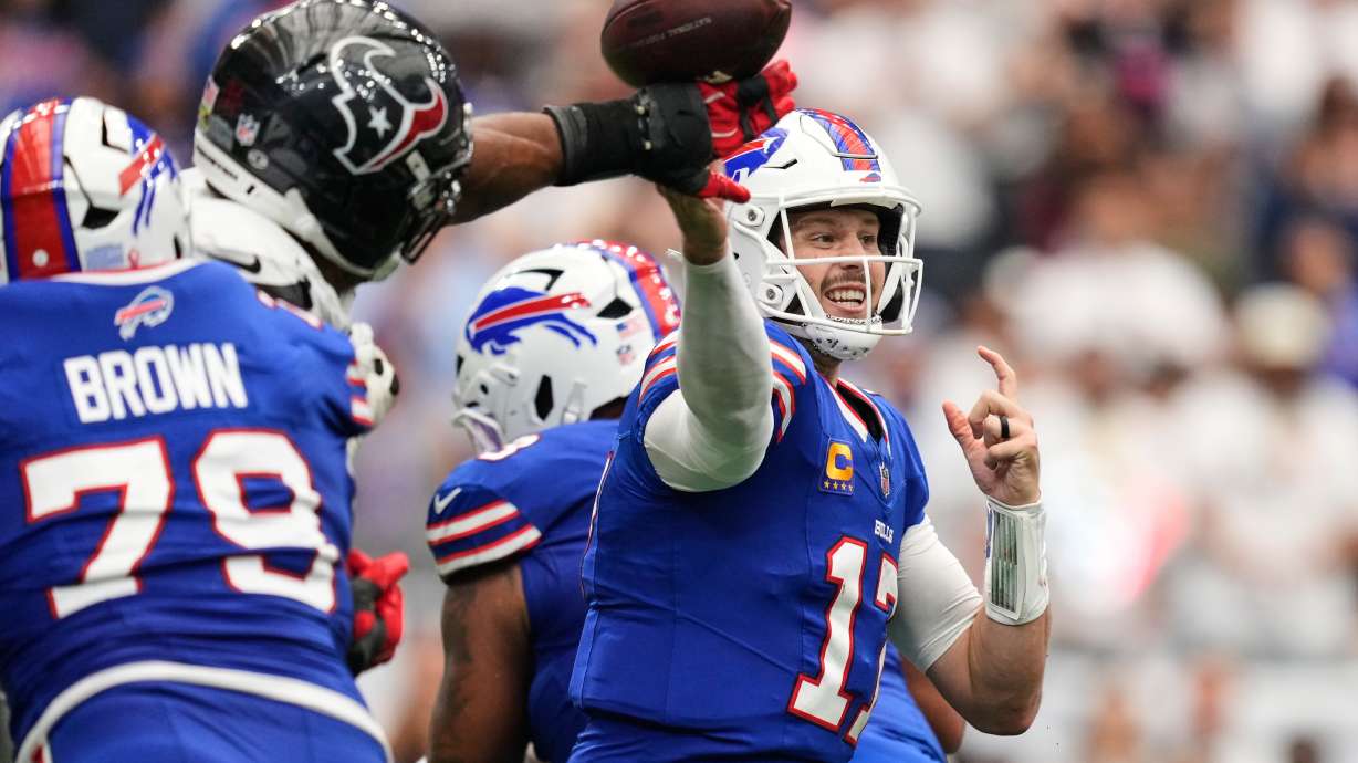 Buffalo Bills quarterback Josh Allen (17) throws an incomplete pass forced by Houston Texans defensive end Danielle Hunter, second from left, during the second half of an NFL football game, Sunday, Sept. 13, 2026, in Houston.