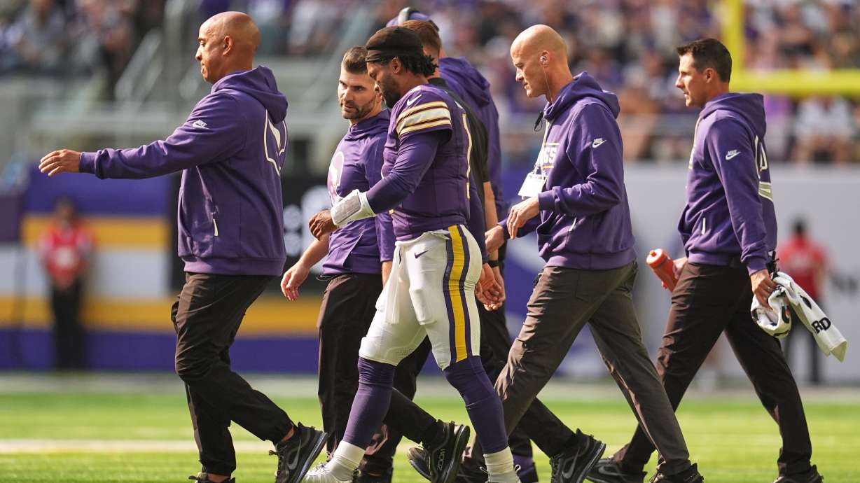Minnesota Vikings quarterback Kyler Murray, center, walks off the field with staff after suffering an unknown injury during the first half of an NFL football game against the Green Bay Packers Sunday, Sept. 13, 2026, in Minneapolis, Minn.