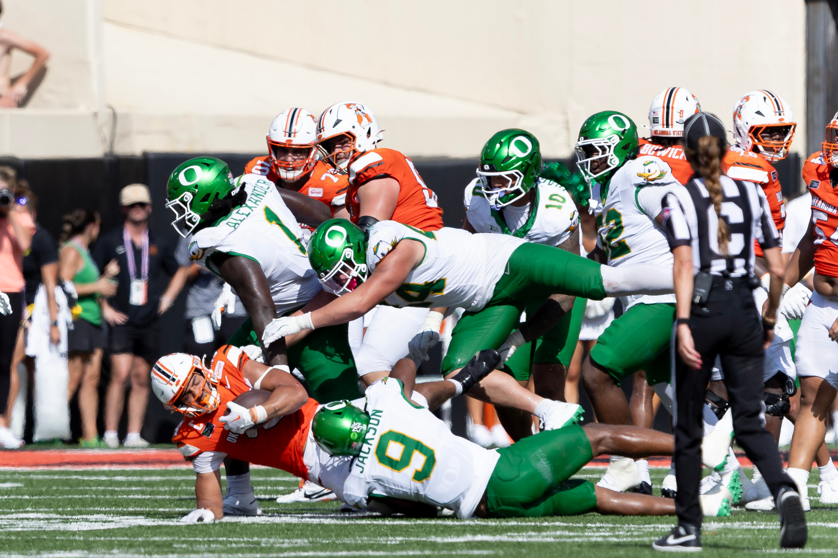 Oklahoma State running back Caleb Hawkins (24) is tackled by Oregon linebacker Devon Jackson (9), linebacker Teitum Tuioti (44) and Bear Alexander in the second half of the NCAA college football game in Stillwater, Okla., Saturday, Sept. 12, 2026. 