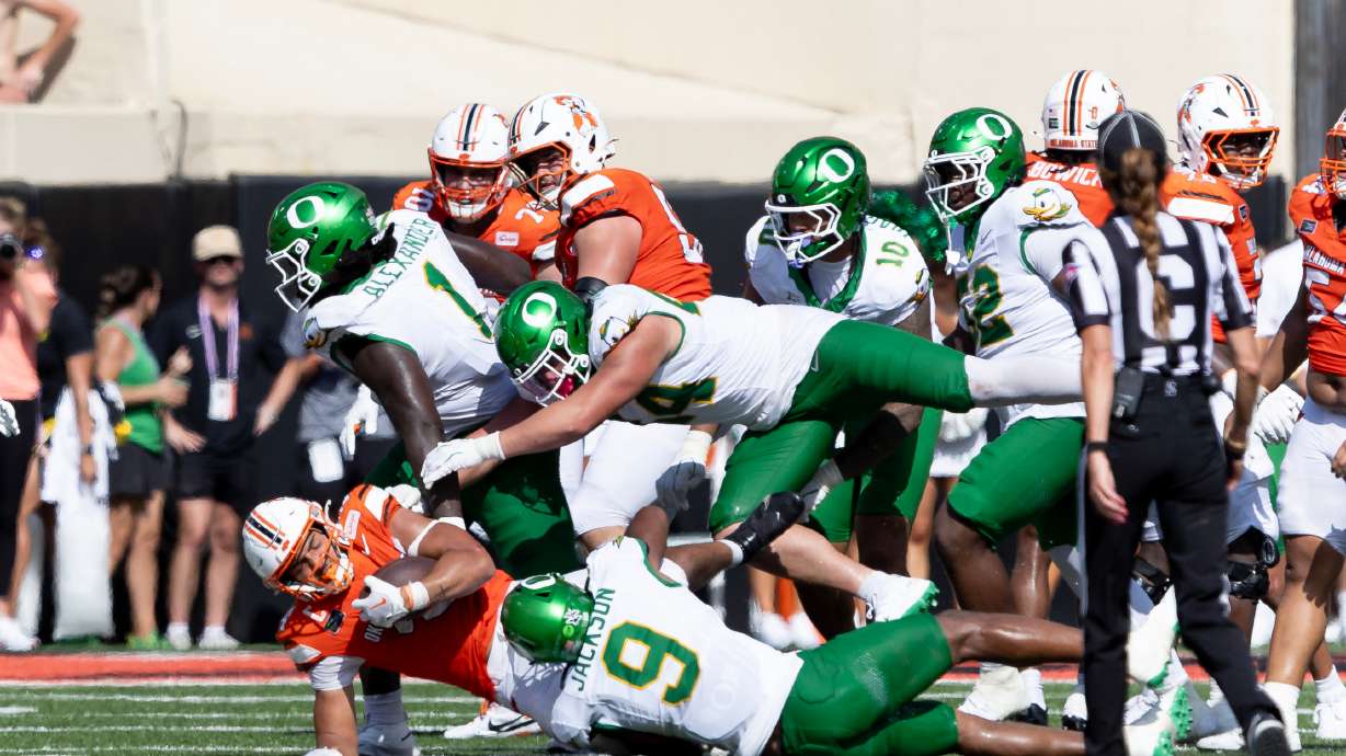 Oklahoma State running back Caleb Hawkins (24) is tackled by Oregon linebacker Devon Jackson (9), linebacker Teitum Tuioti (44) and Bear Alexander in the second half of the NCAA college football game in Stillwater, Okla., Saturday, Sept. 12, 2026.