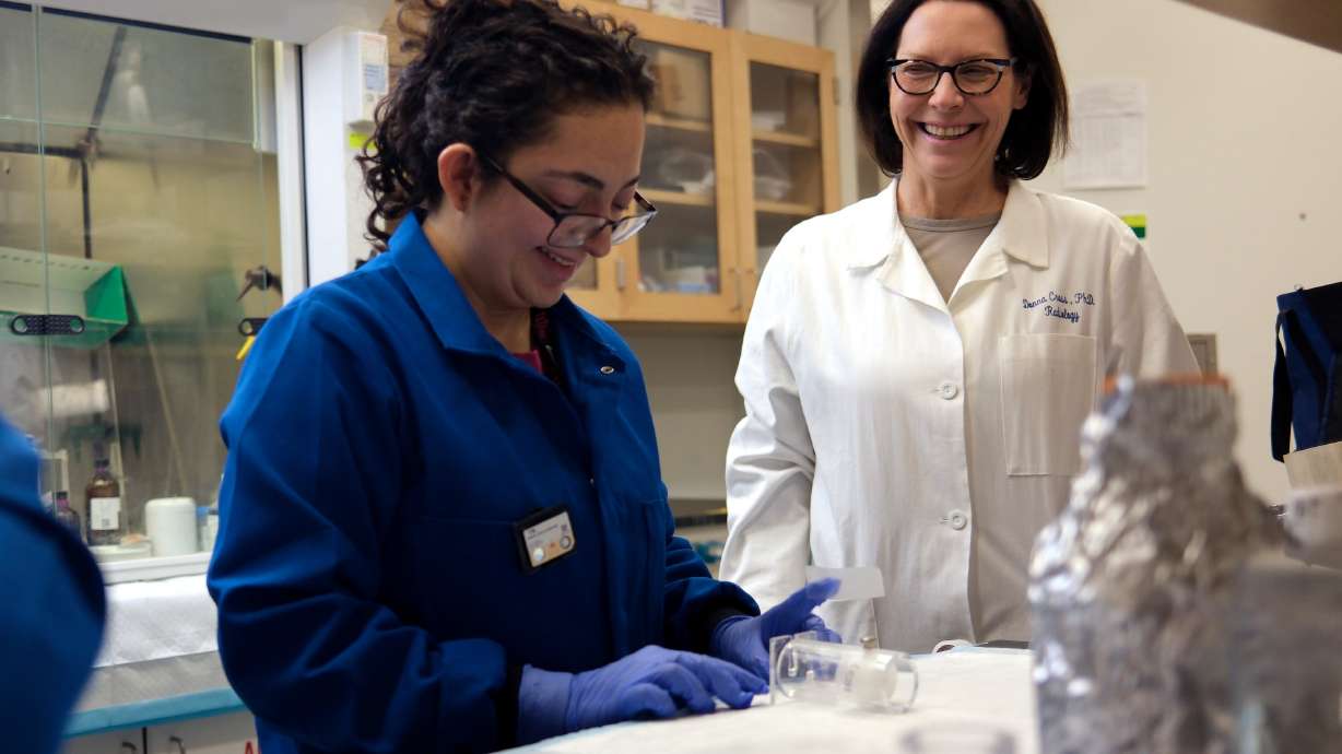 Jenna Aguilar Medina and Donna Cross talk while setting up an experiment in the Sorenson Molecular Biotech building at the University of Utah in Salt Lake City on Aug. 19.