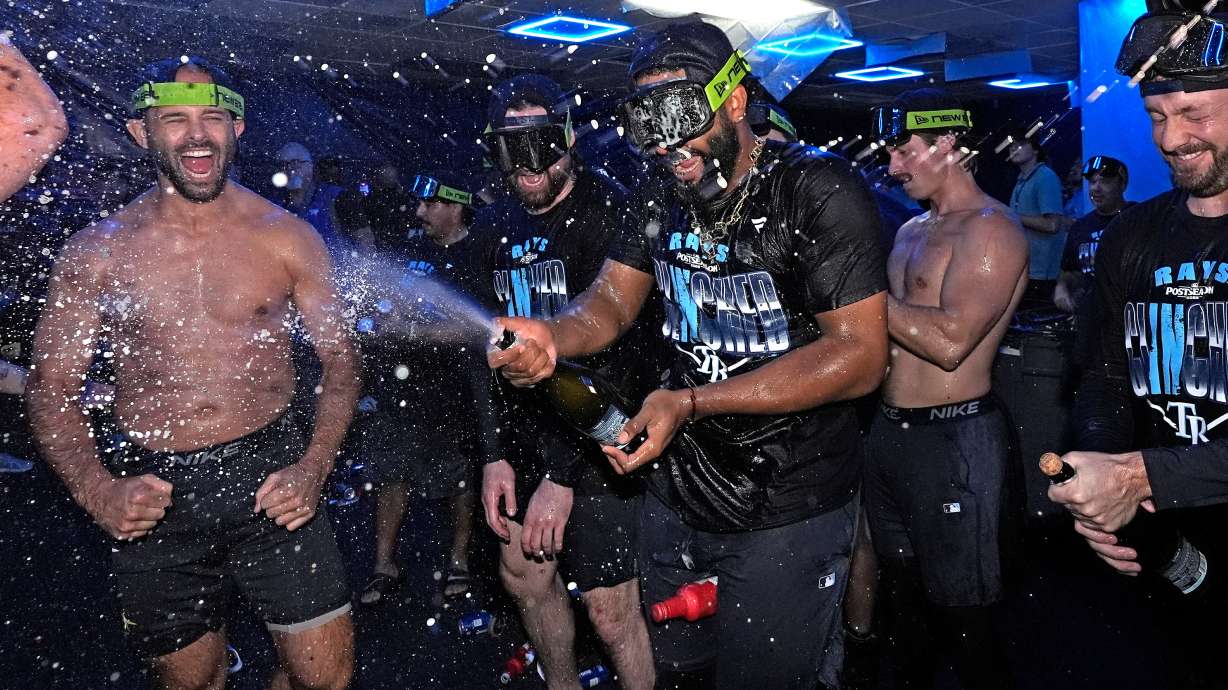Tampa Bay Rays' Junior Caminero spreays champagne on teammates after the team clinched a playoff spot with a win over the Houston Astros during a baseball game Friday, Sept. 11, 2026, in St. Petersburg, Fla.