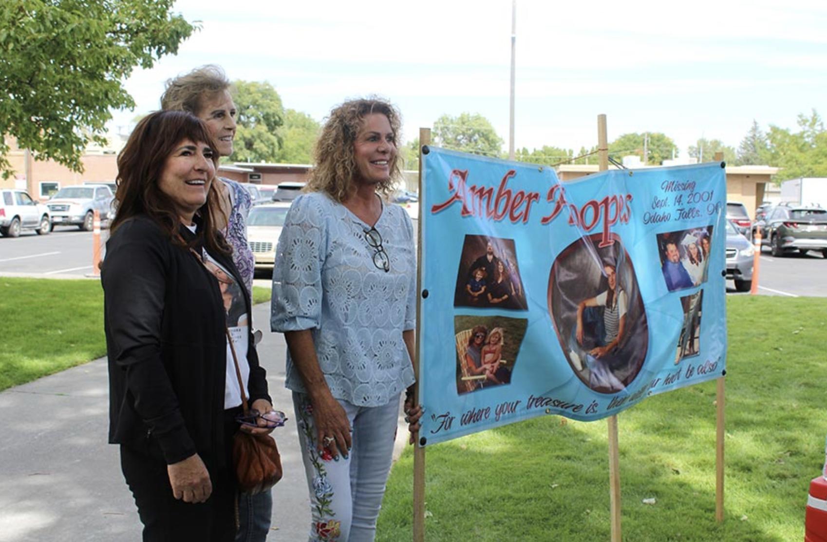 Amber Hoopes’ family members stand next to the sign to raise awareness for her disappearance.